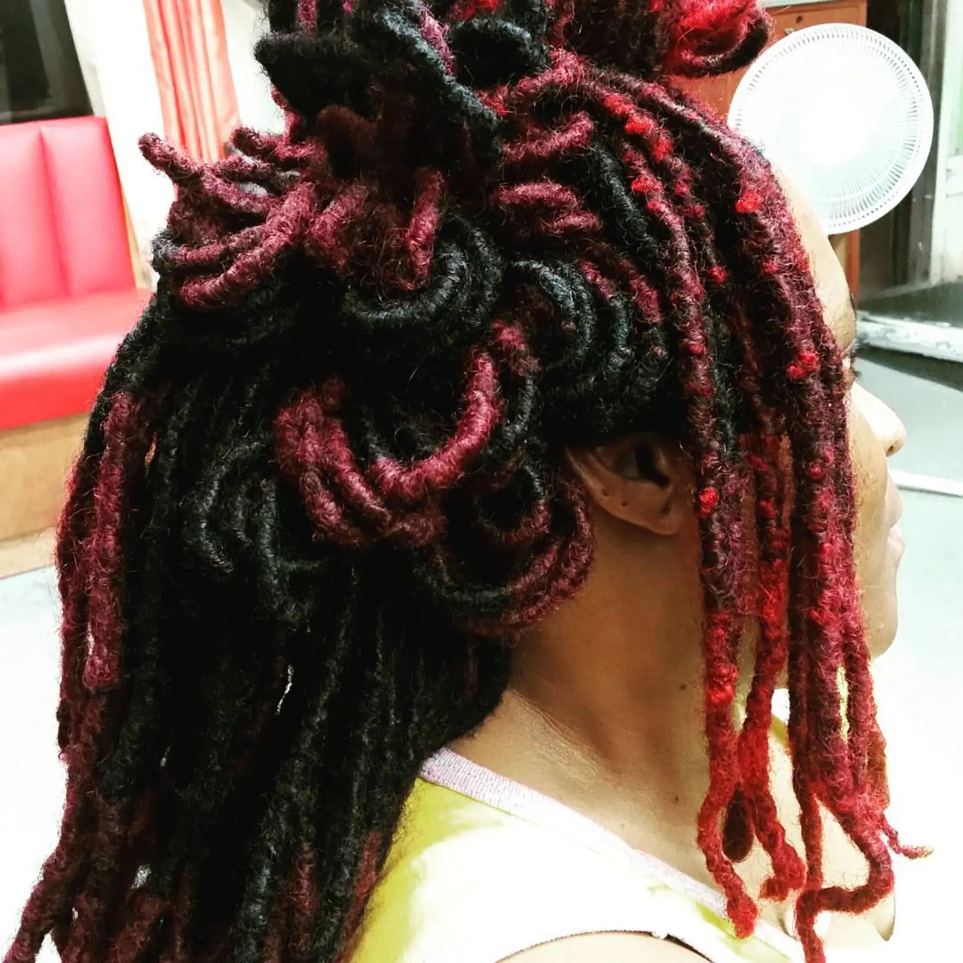 Dreadlocks styled in a crown updo with black and red color combination. 1