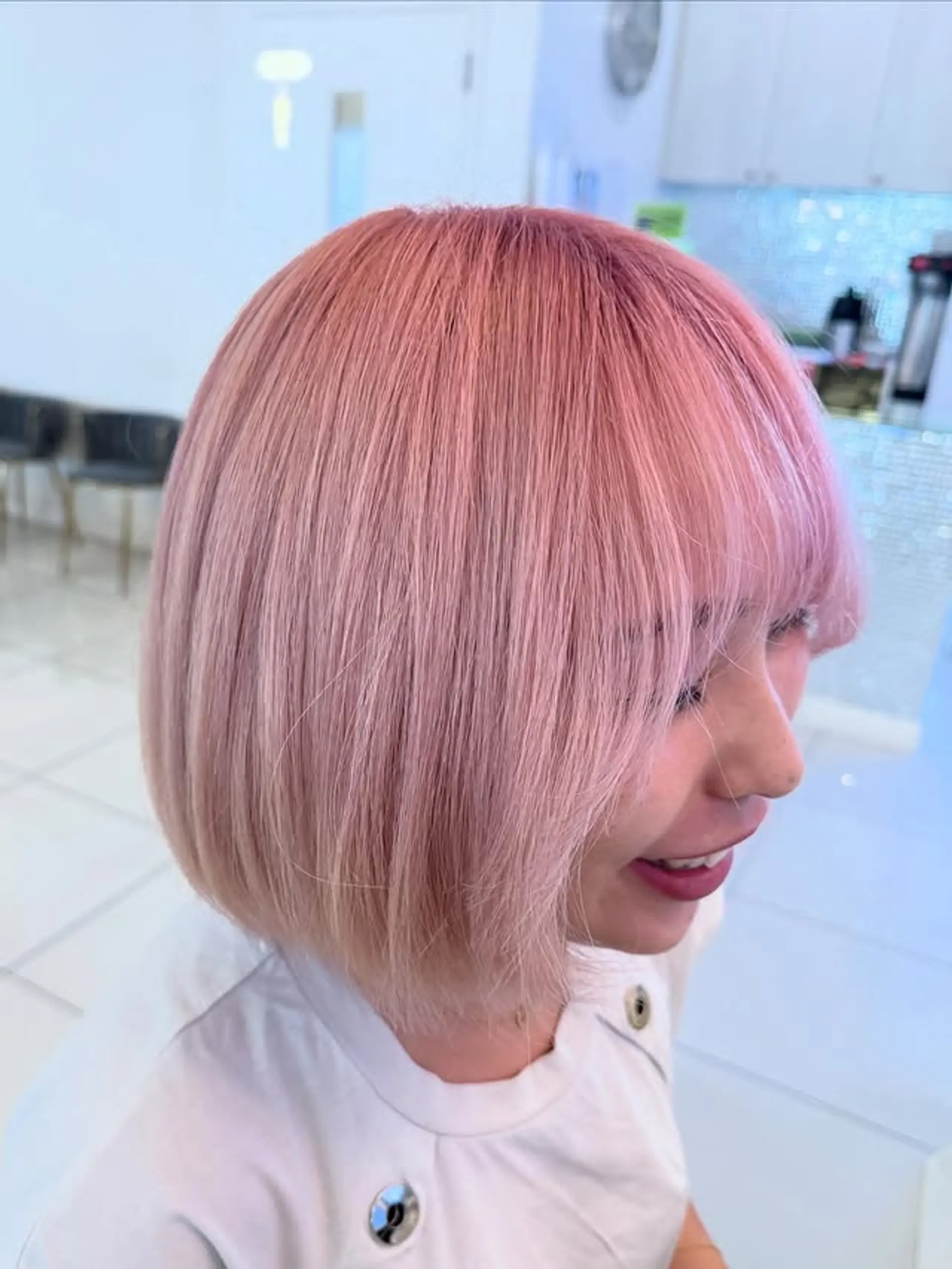 A medium-length bob with blunt bangs, styled straight and colored in a pastel pink. 1