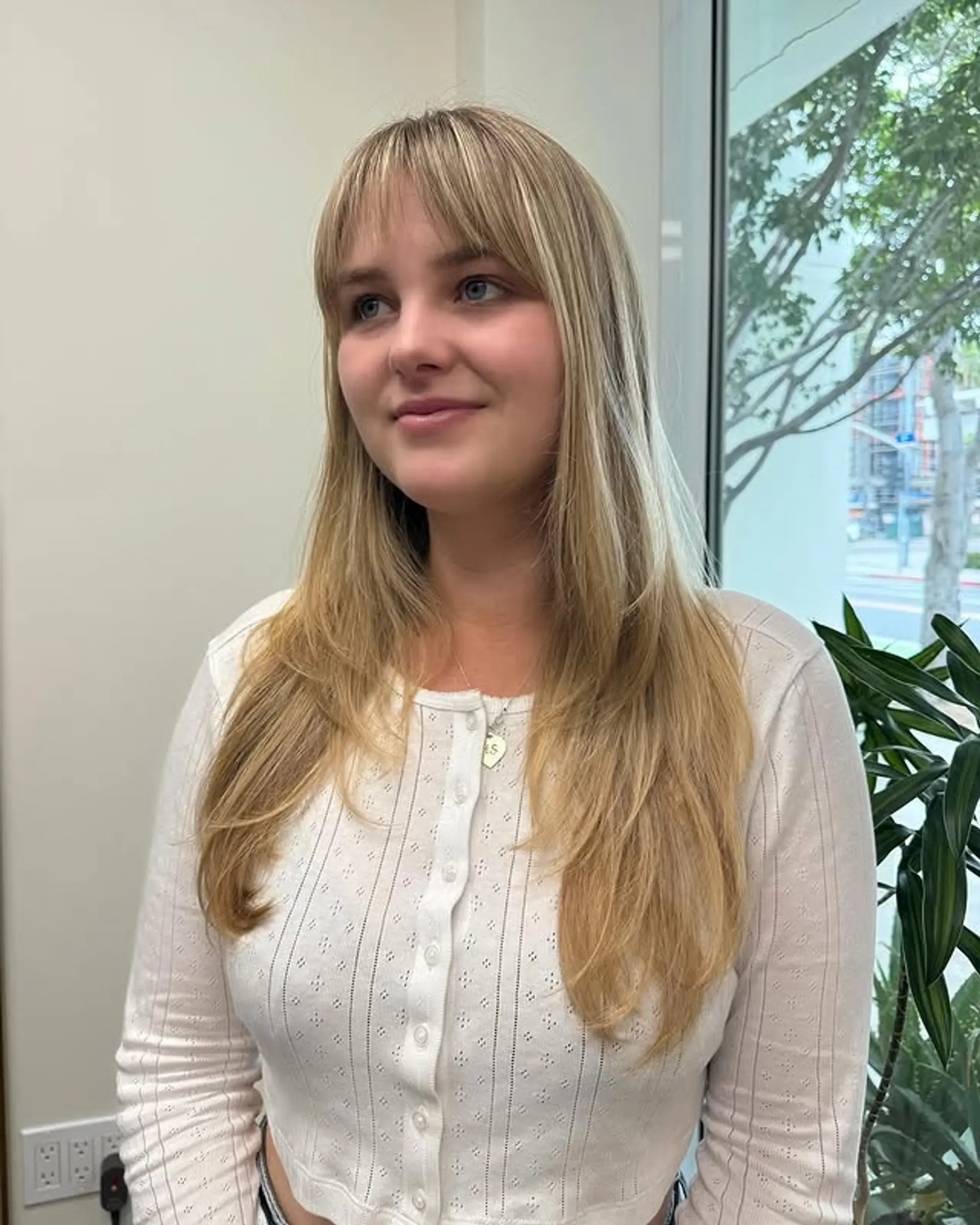 A long layered haircut with face-framing layers and curtain bangs. 1