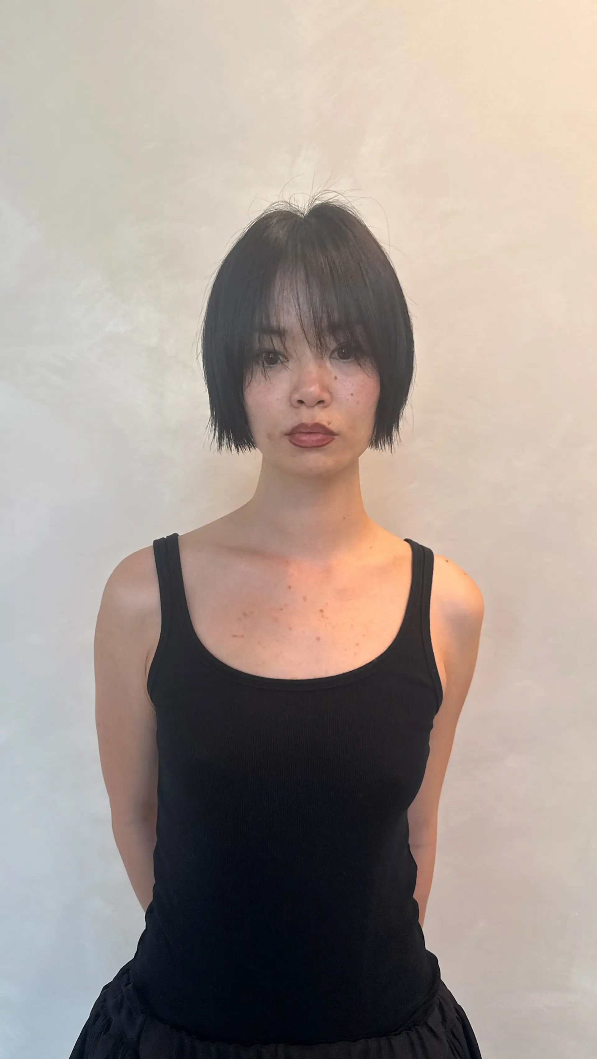 A textured chin-length bob paired with wispy, eye-skimming bangs in natural black. 1