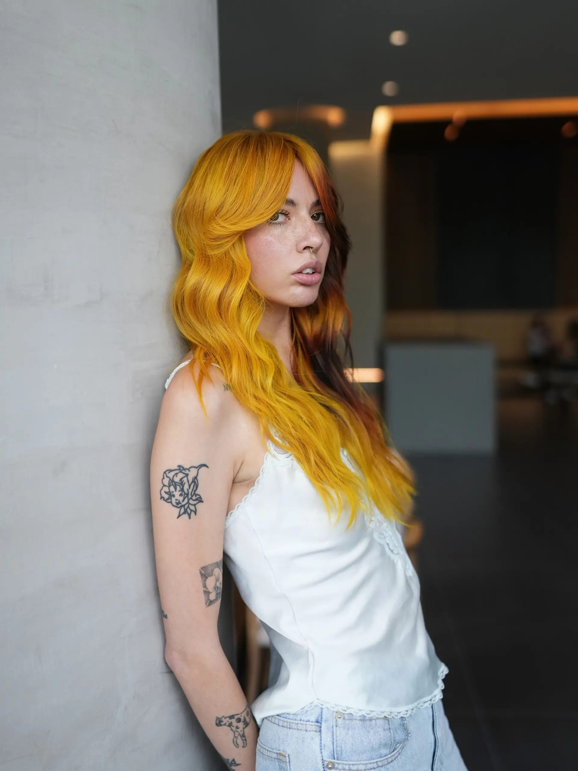 Long wavy hair featuring a vibrant golden-yellow hue, face-framing curtain bangs, and a contrasting deep auburn underlayer. 1
