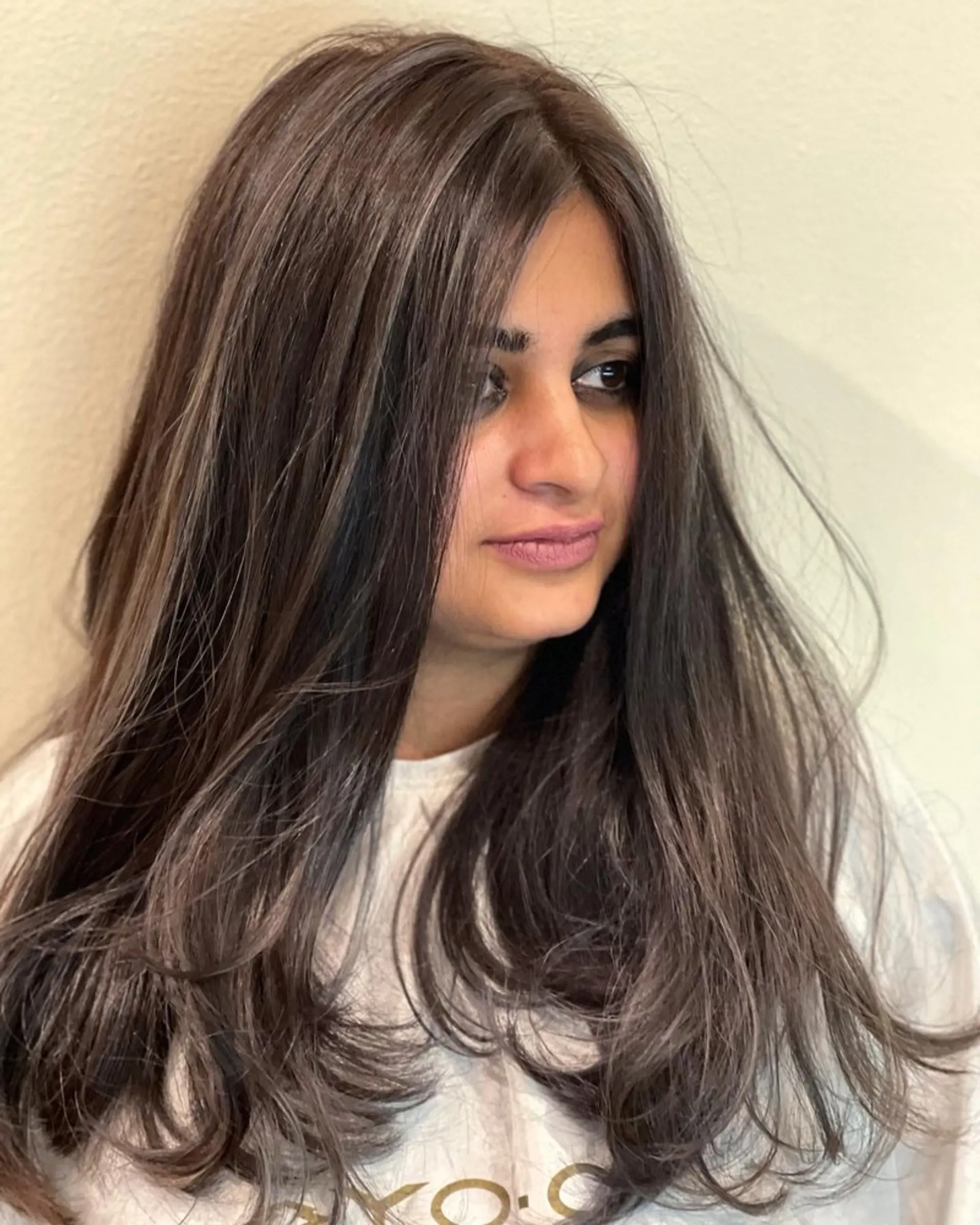 Long, layered hairstyle with an ash brown base and subtle ash blonde balayage. 1