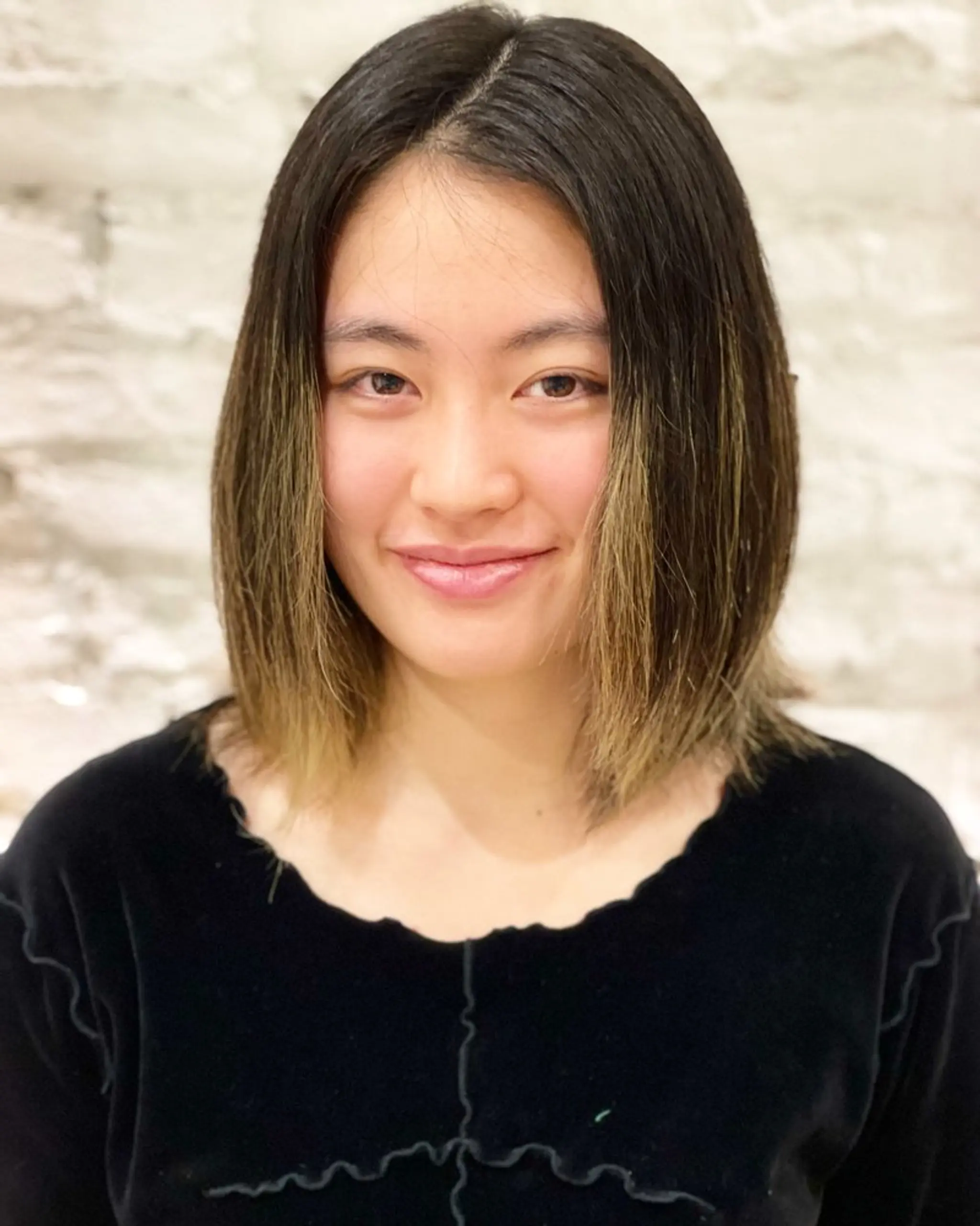 A stylish medium-length bob with a dark shadow root and blonde balayage.