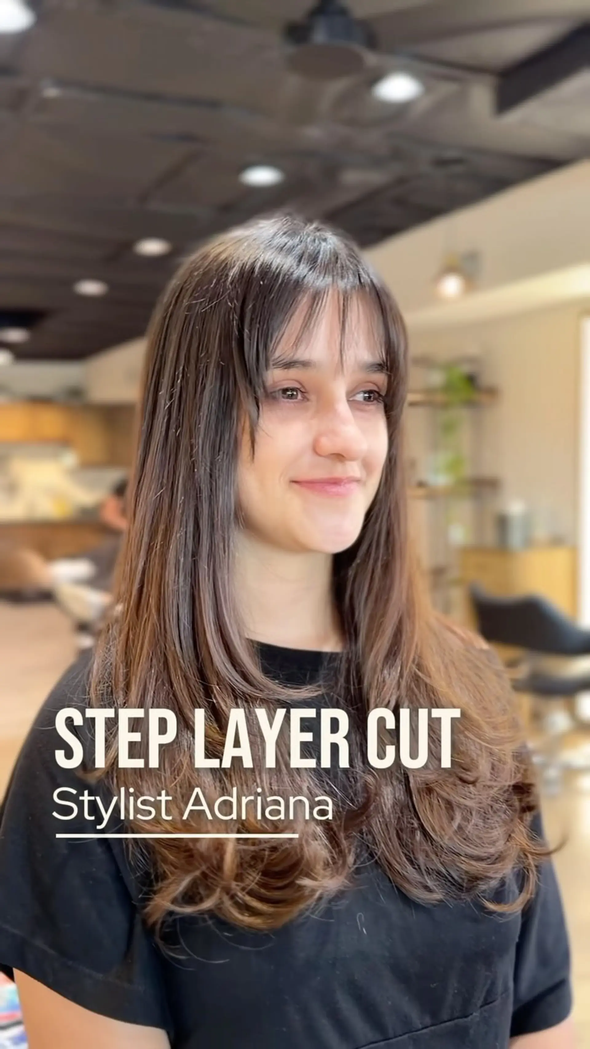 Long brown hair styled with voluminous step layers, face-framing pieces, and wispy bangs. 1