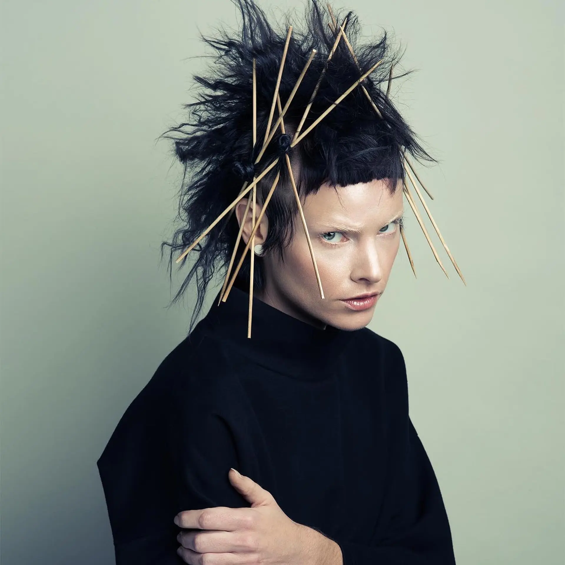 An avant-garde, punk-inspired editorial look featuring textured spikes, micro bangs, and sculptural wooden sticks woven throughout. 1