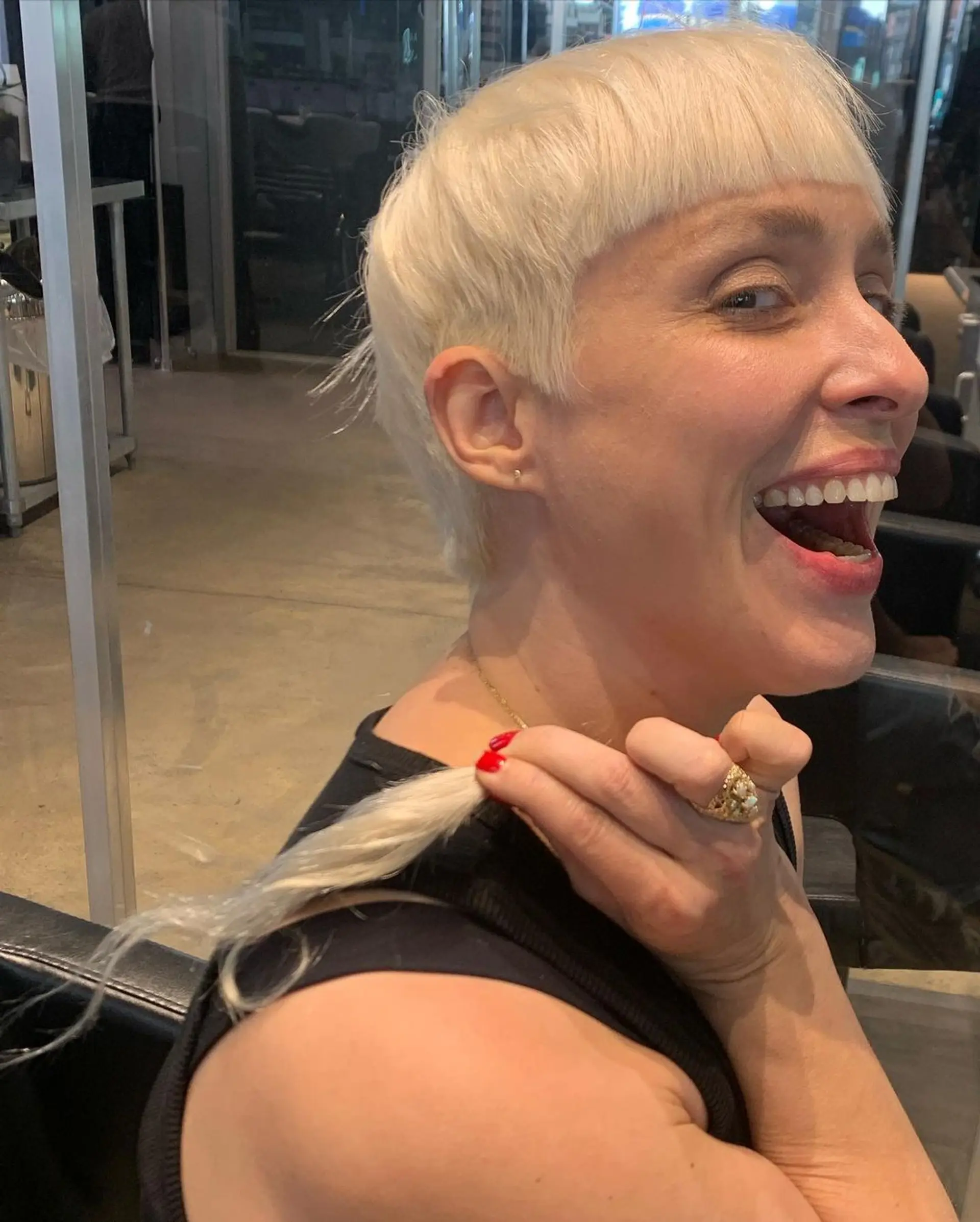 Short, straight platinum blonde hair styled in a pixie cut with distinguishing micro bangs. 2