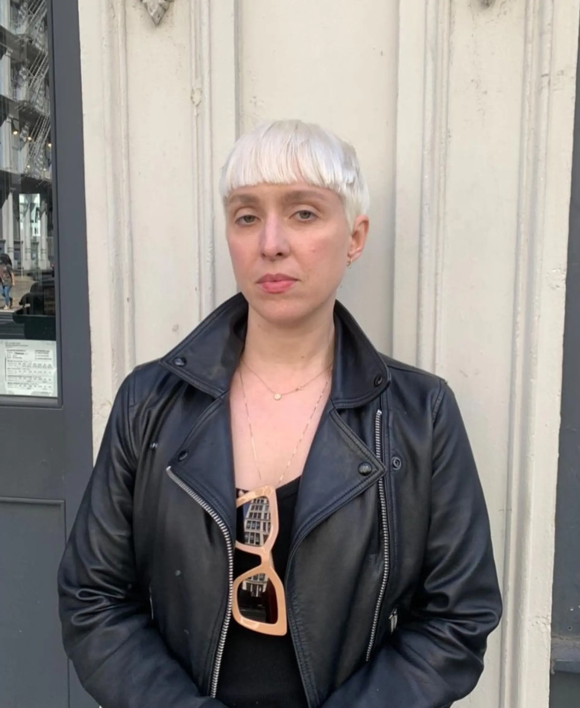 Short, straight platinum blonde hair styled in a pixie cut with distinguishing micro bangs. 1