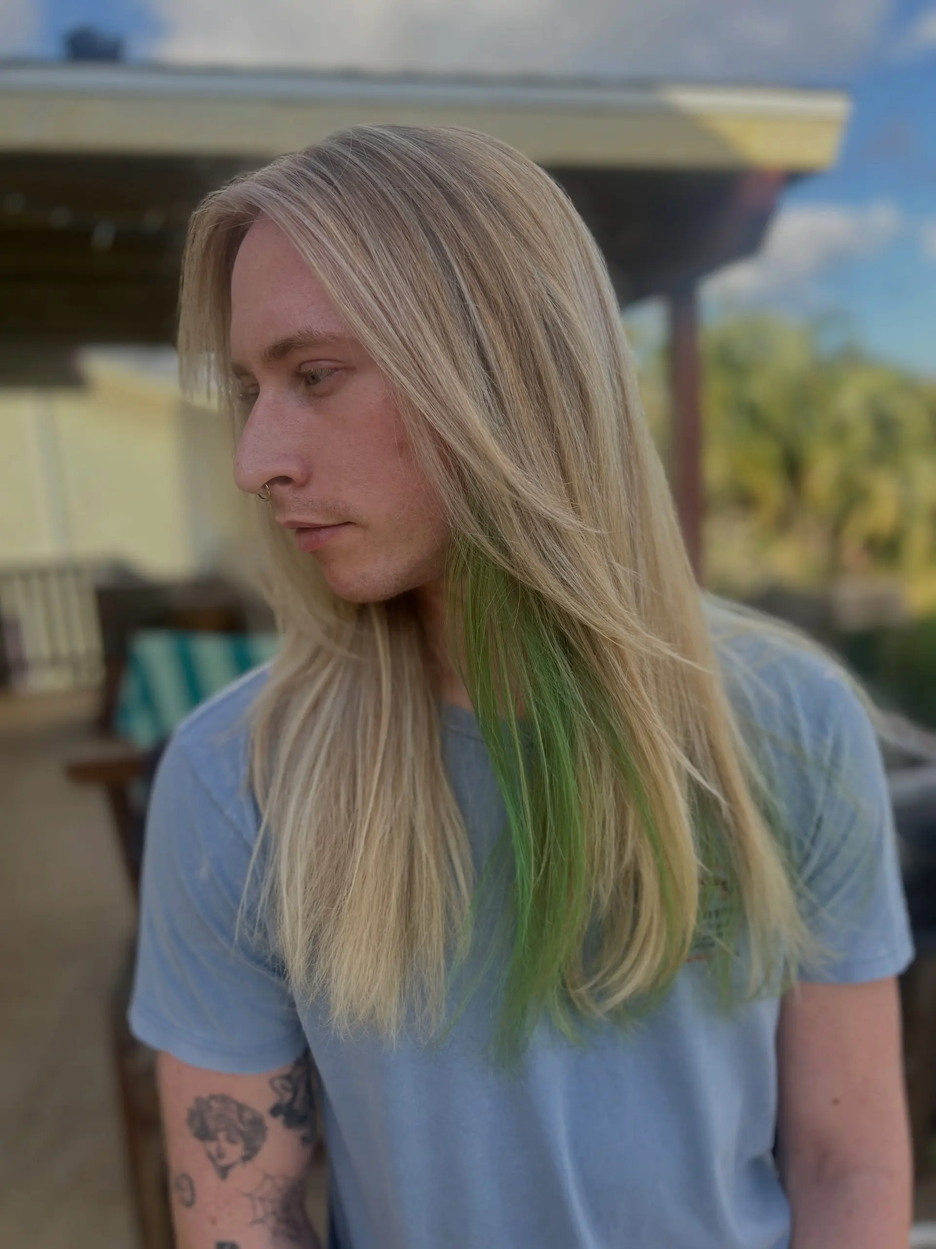 Long straight blonde hair with face-framing layers and a vibrant green peekaboo underlayer. 1