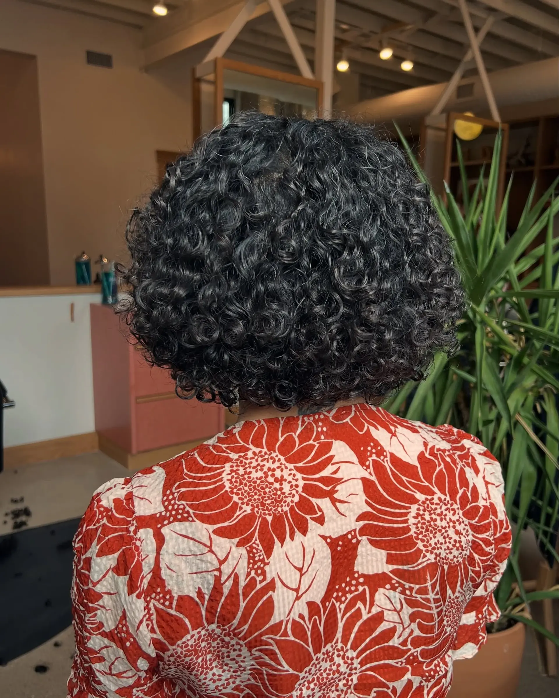 A classic short bob, styled with natural, defined curls that create a voluminous shape. 1