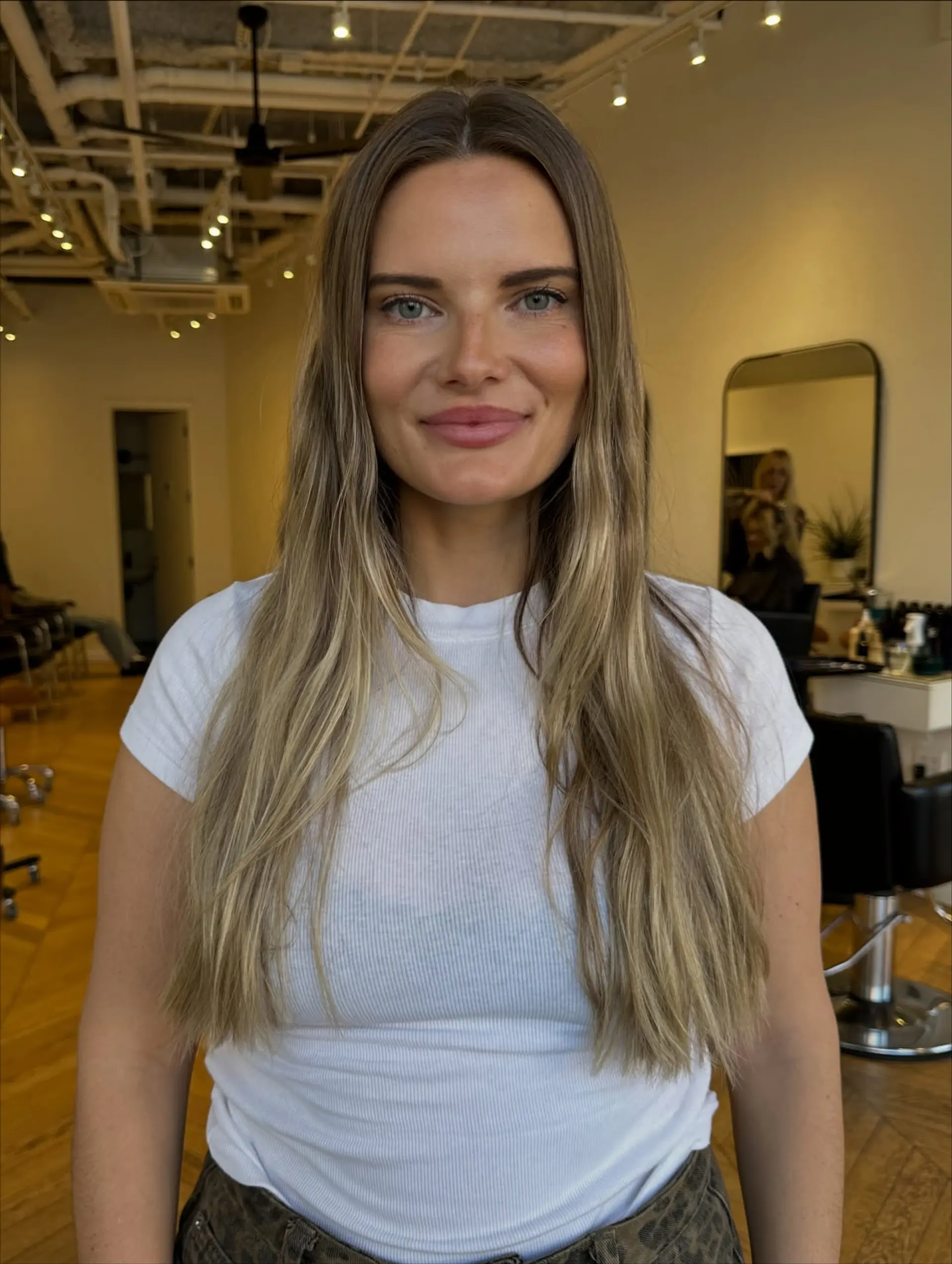 Long layered dirty blonde hair with soft face-framing highlights and a middle part. 1