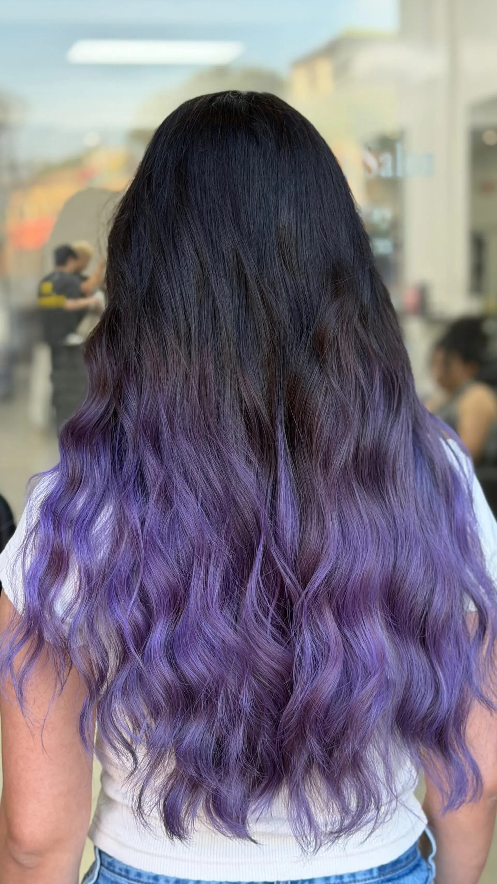 Long wavy hair with a seamless ombre balayage blending from dark roots into vibrant purple ends. 1