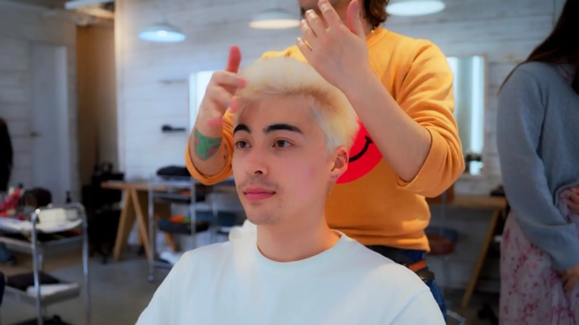 A short, bleached platinum blonde haircut styled upward with texture and volume. 1
