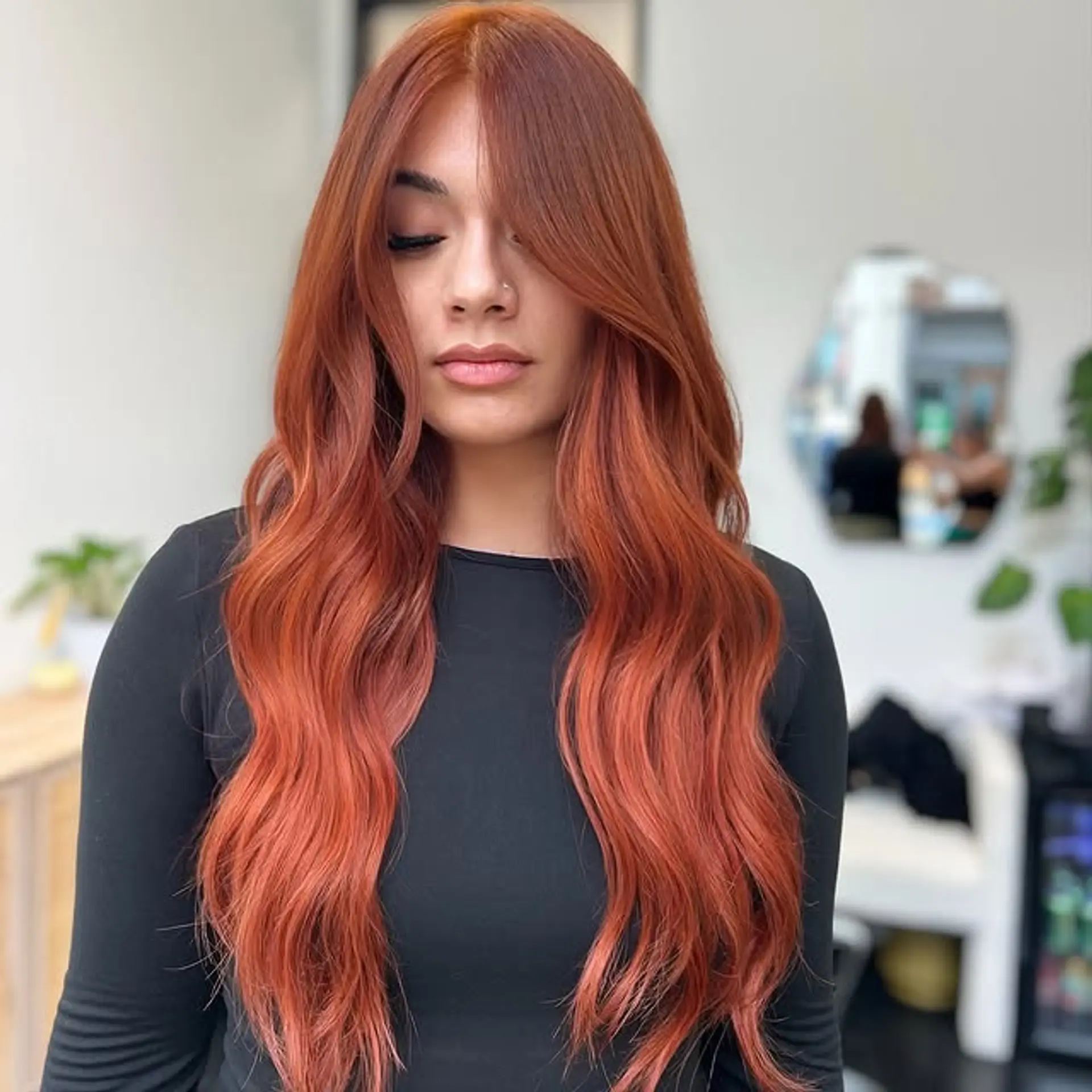 Long, wavy hairstyle with face-framing layers, colored in a vibrant copper red. 1