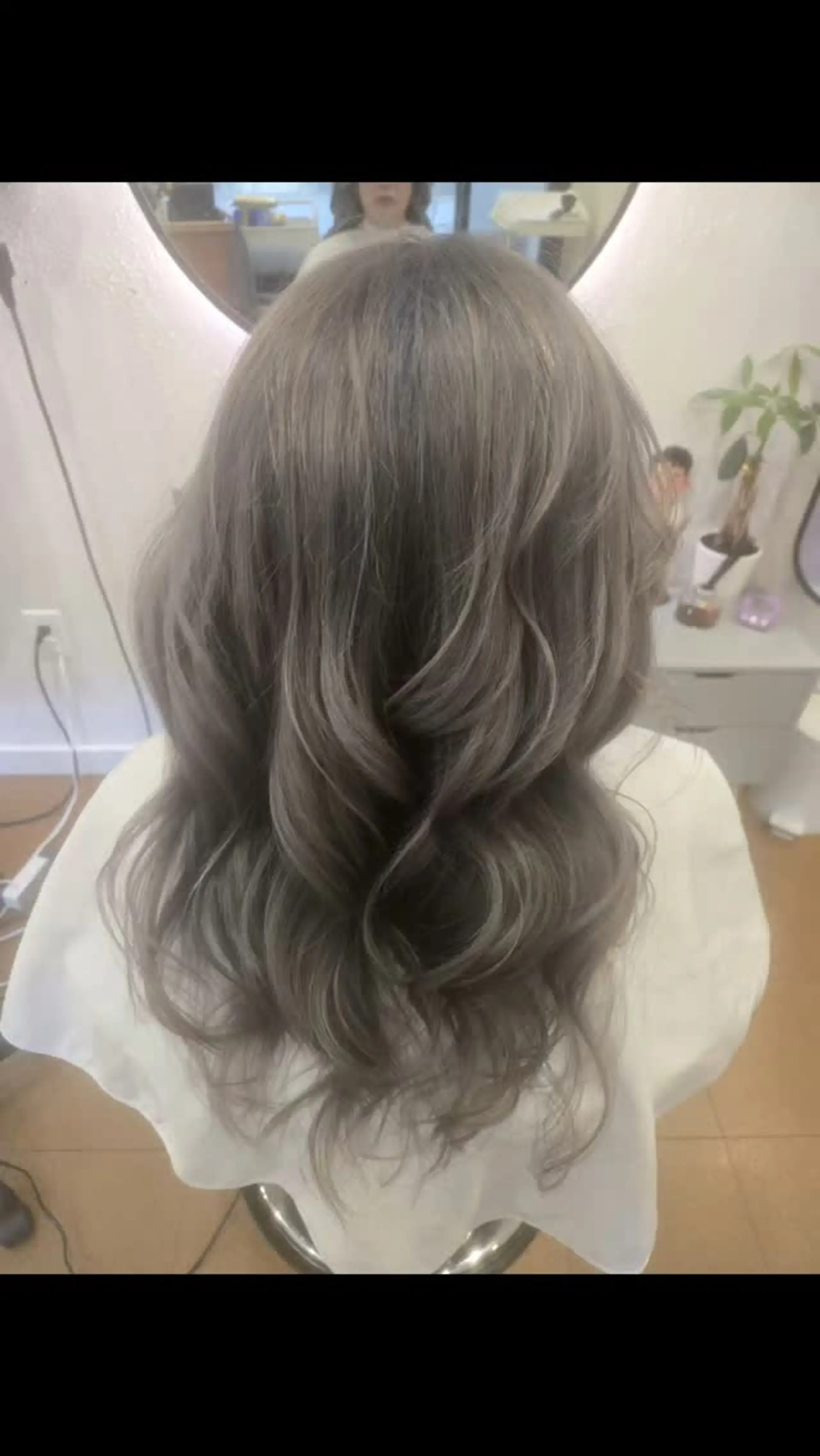 Medium-to-long hair colored in a cool-toned ash violet shade, styled with voluminous, soft curls. 1