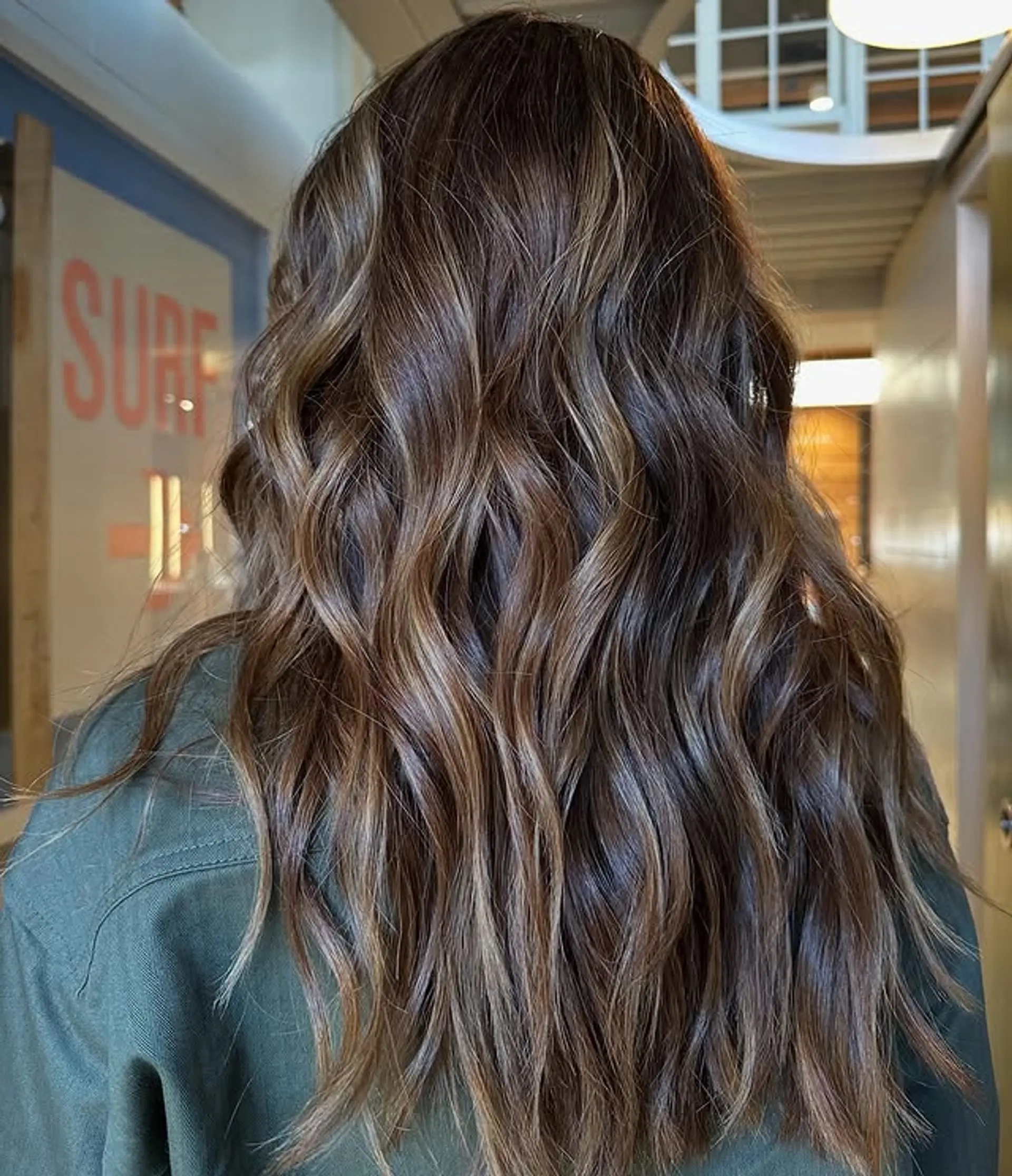 Long, wavy hair with a bronzed balayage that blends brown and blonde for a beachy, sun-kissed look. 1