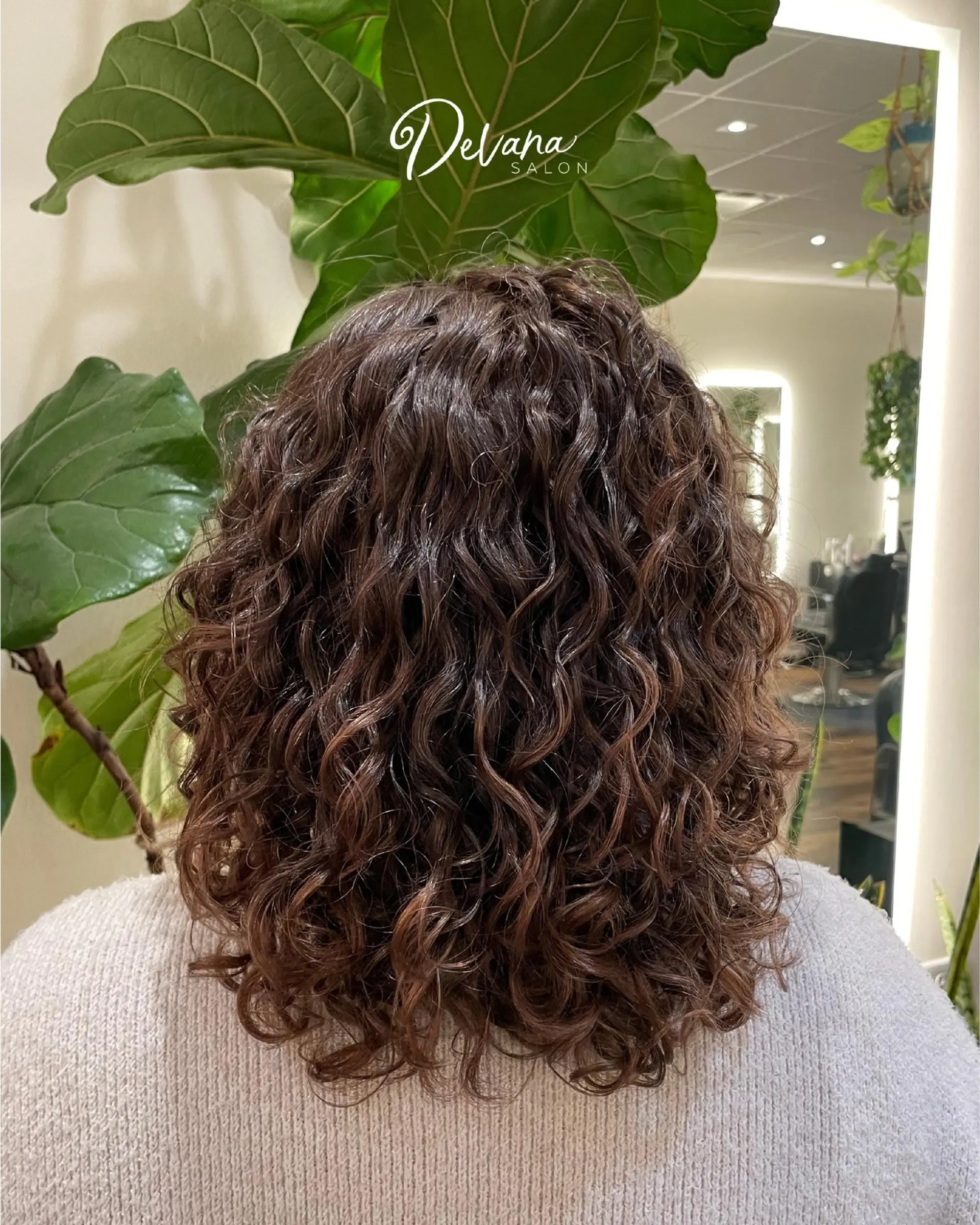Shoulder-length haircut styled with bouncy, defined curls and natural volume. 1