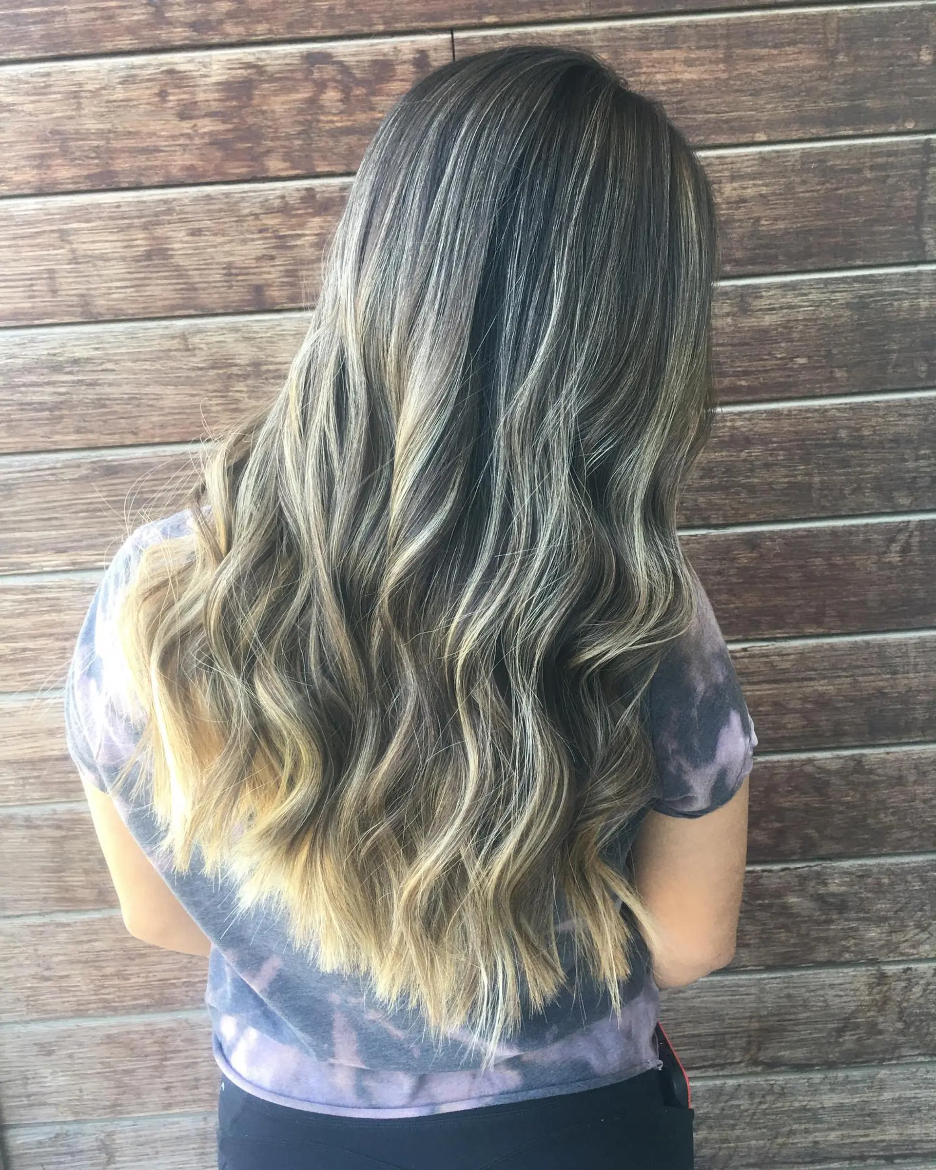 Long dark hair with fine ash and honey blonde balayage highlights styled in soft, loose waves. 1