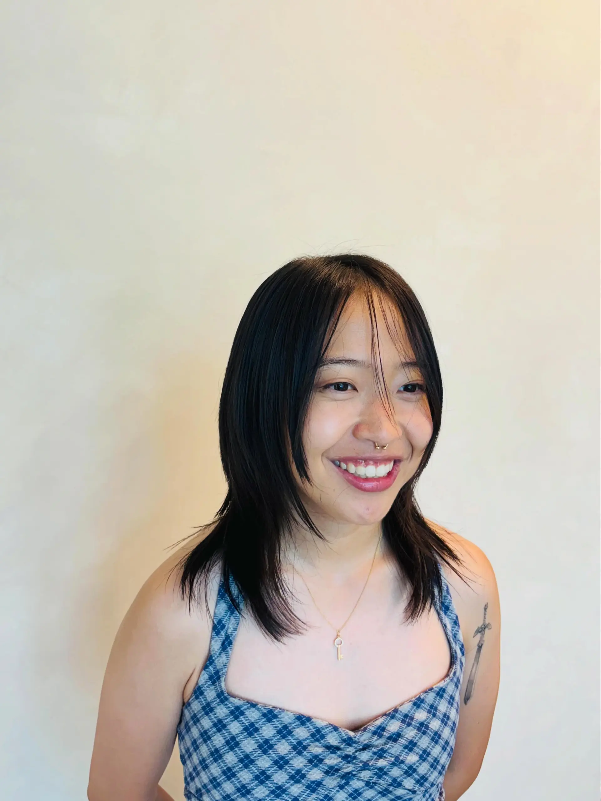 A textured medium-length high layered haircut featuring wispy face-framing strands and soft, feathered ends. 1