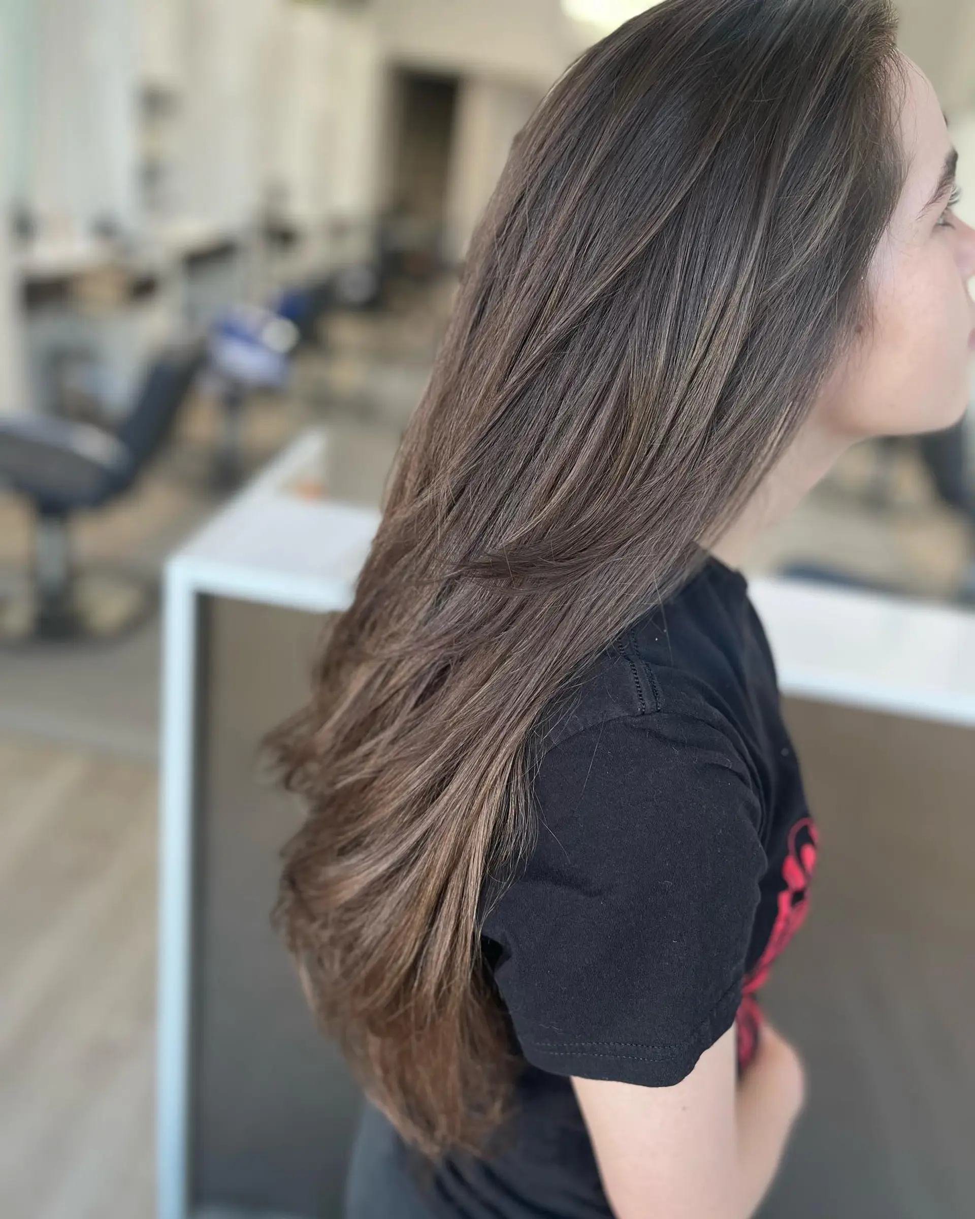 Long ash-brown hair cut into cascading face-framing layers, styled with a smooth, voluminous round-brush blowout. 1
