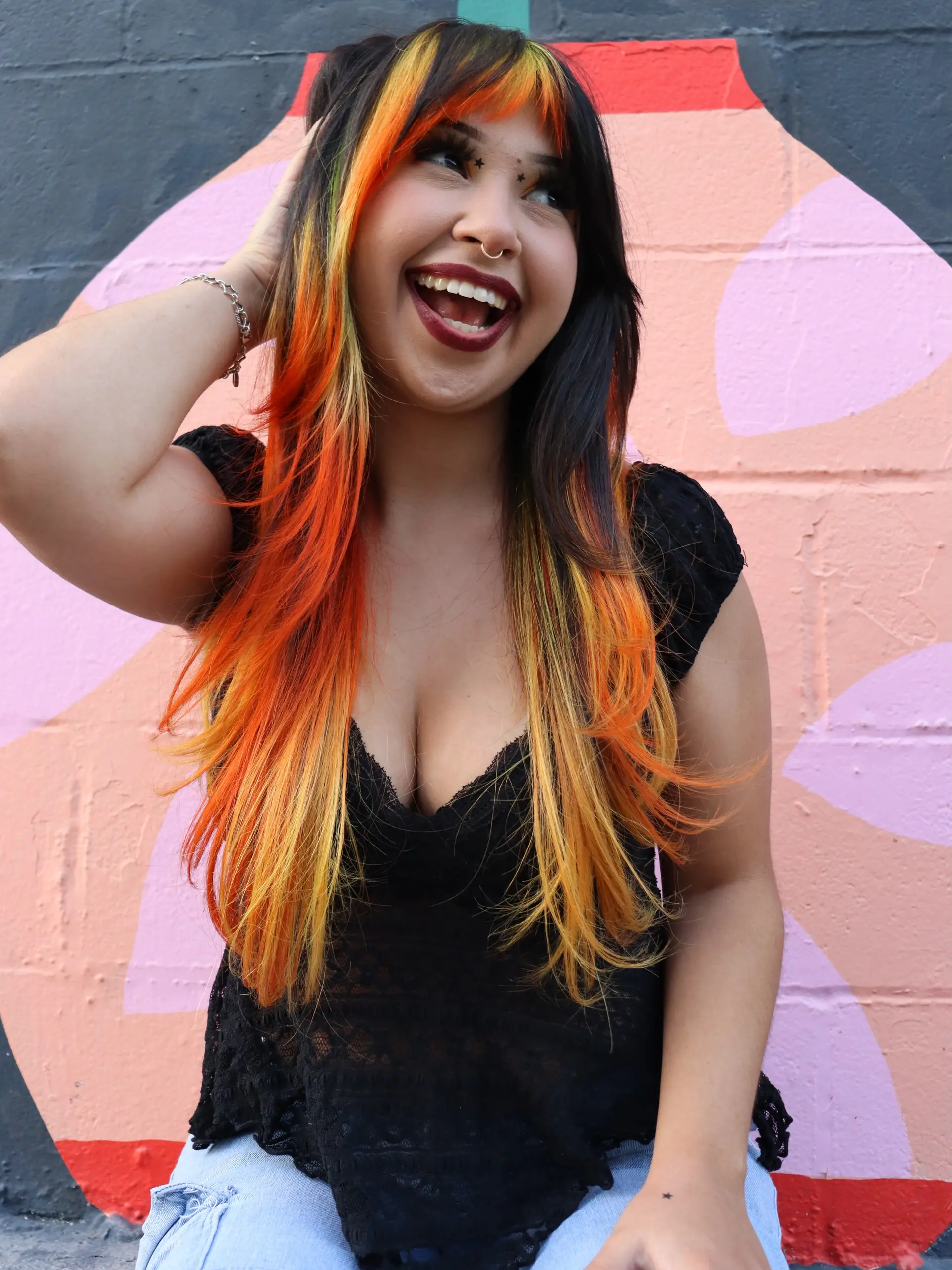 Long dark hair accented with vivid fire-toned orange, yellow, and red color throughout the bangs and face-framing strands. 1