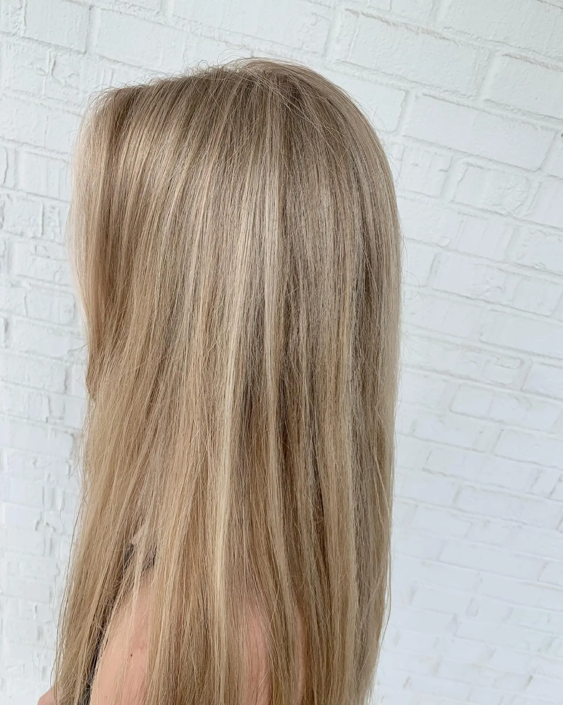 Long, straight hair styled sleek with seamless, fine blonde highlights throughout. 1