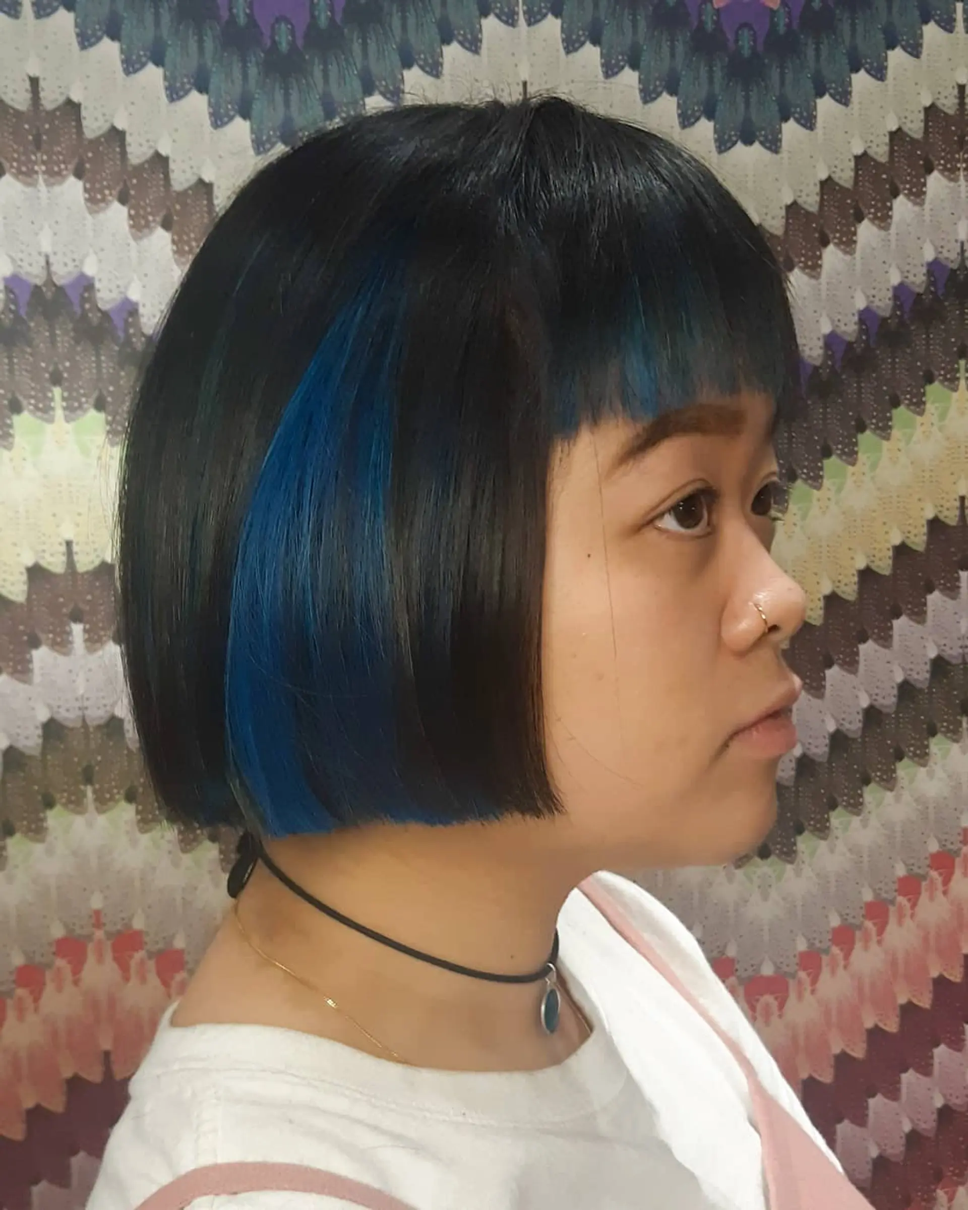 A short, blunt bob with a full fringe, accented by vibrant blue highlights. 2