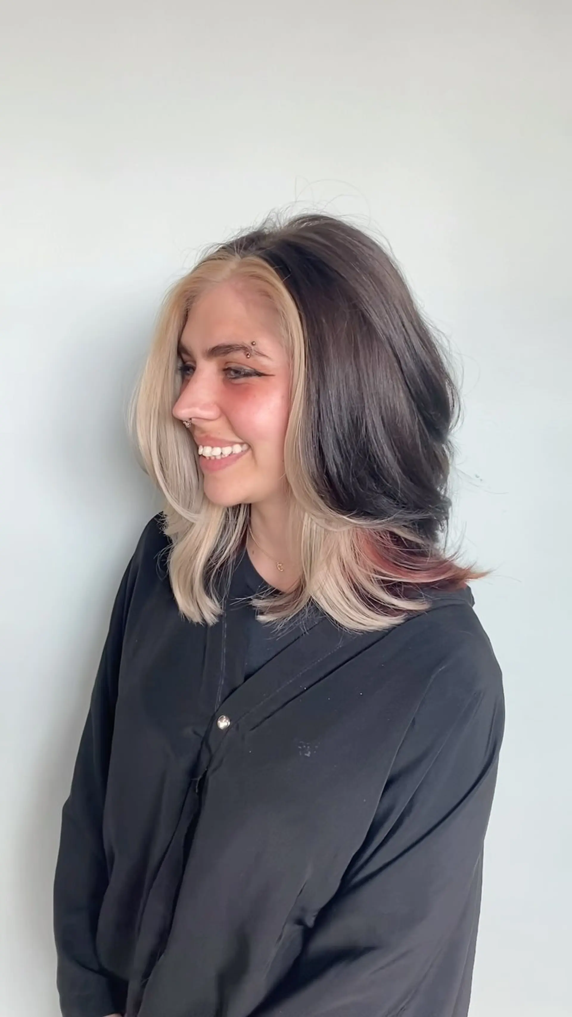 Shoulder-length layered cut featuring high-contrast calico color blocking with bold platinum face-framing sections, dark charcoal crown, and warm copper peeking through the flared ends. 1