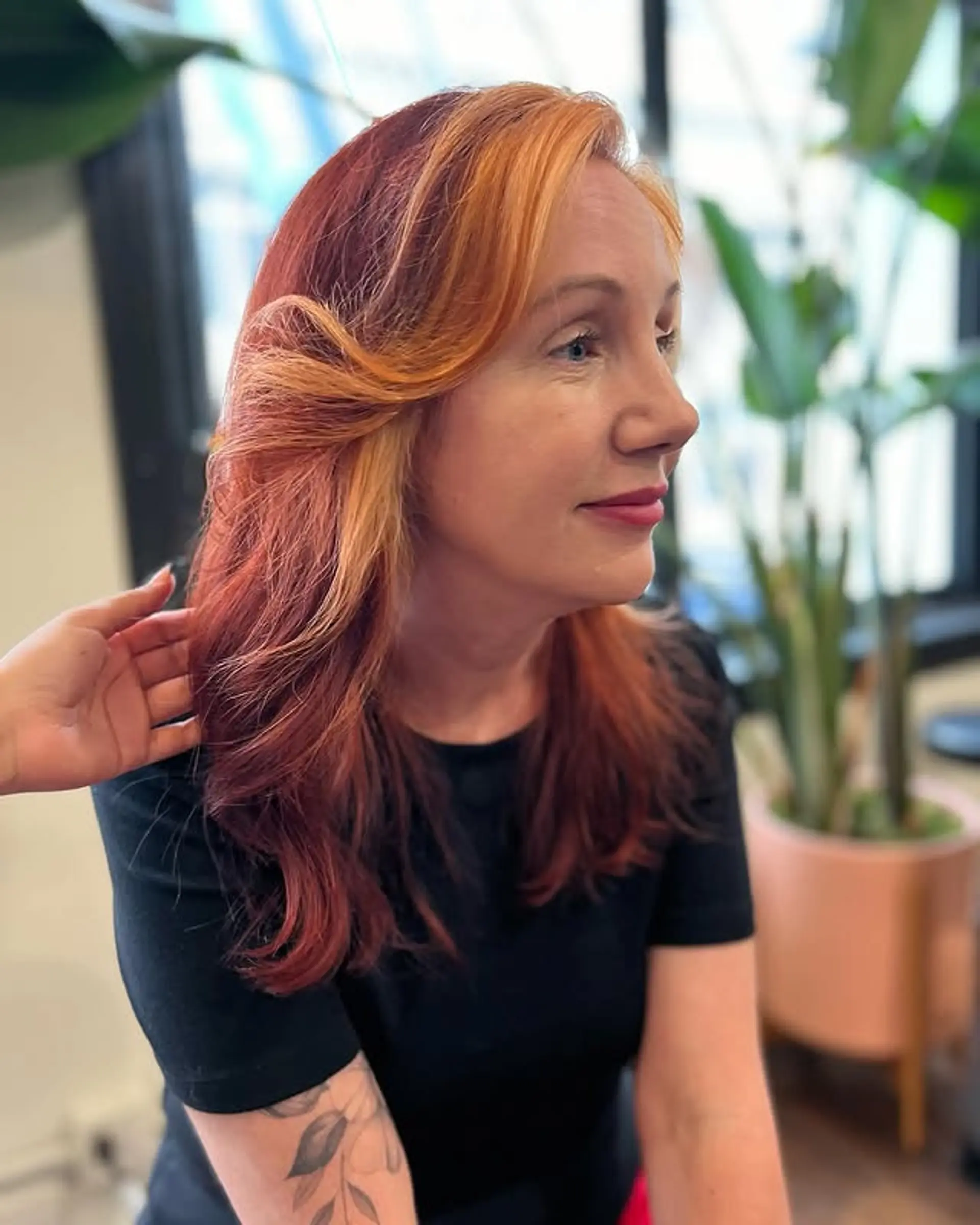 A medium-length wavy hairstyle with face-framing layers and a blend of copper, red, and blonde tones. 1