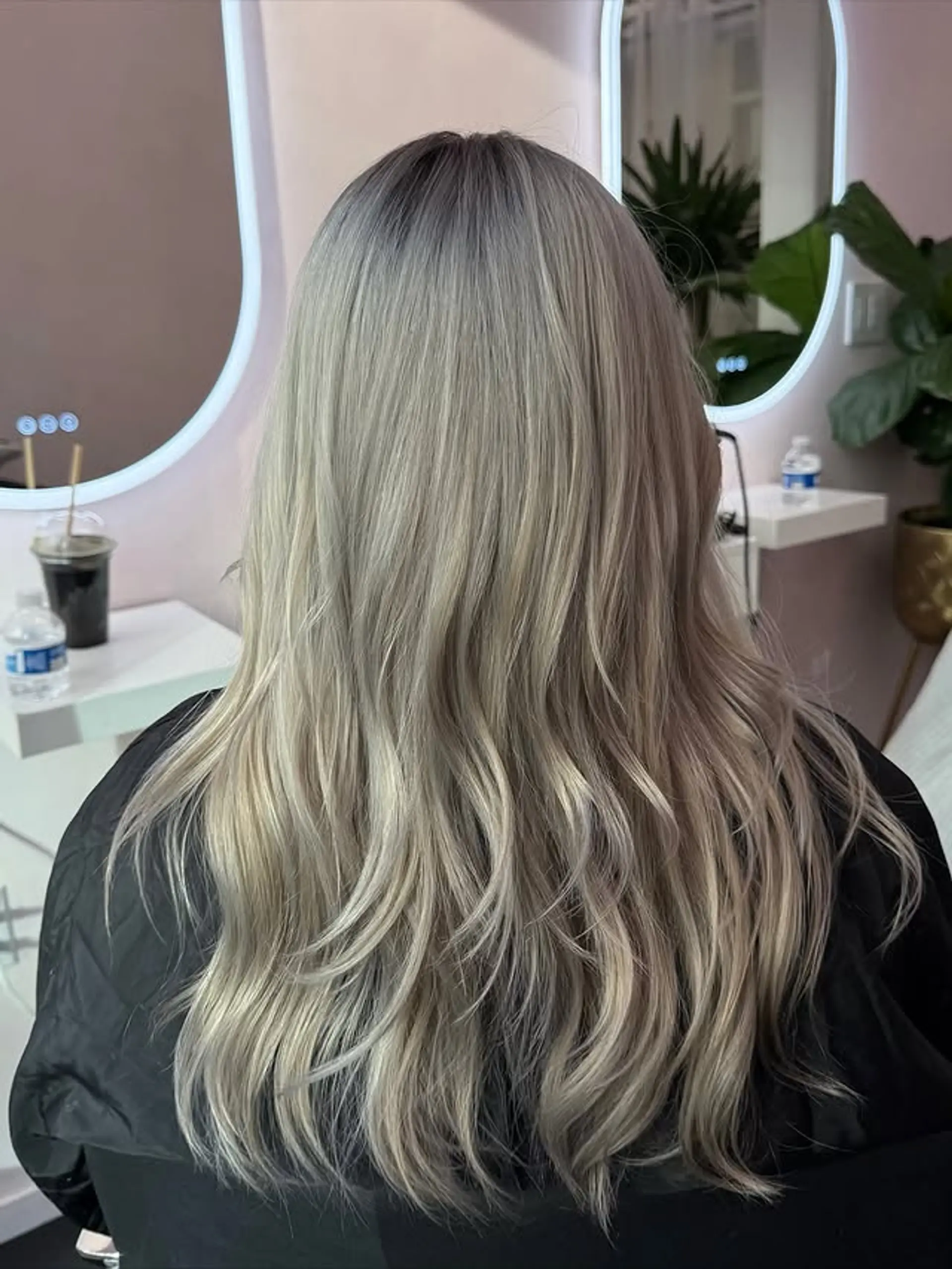 Long, wavy ash blonde hair with dark, natural-looking roots blending into cool-toned, dimensional ash and platinum blonde lengths. 1