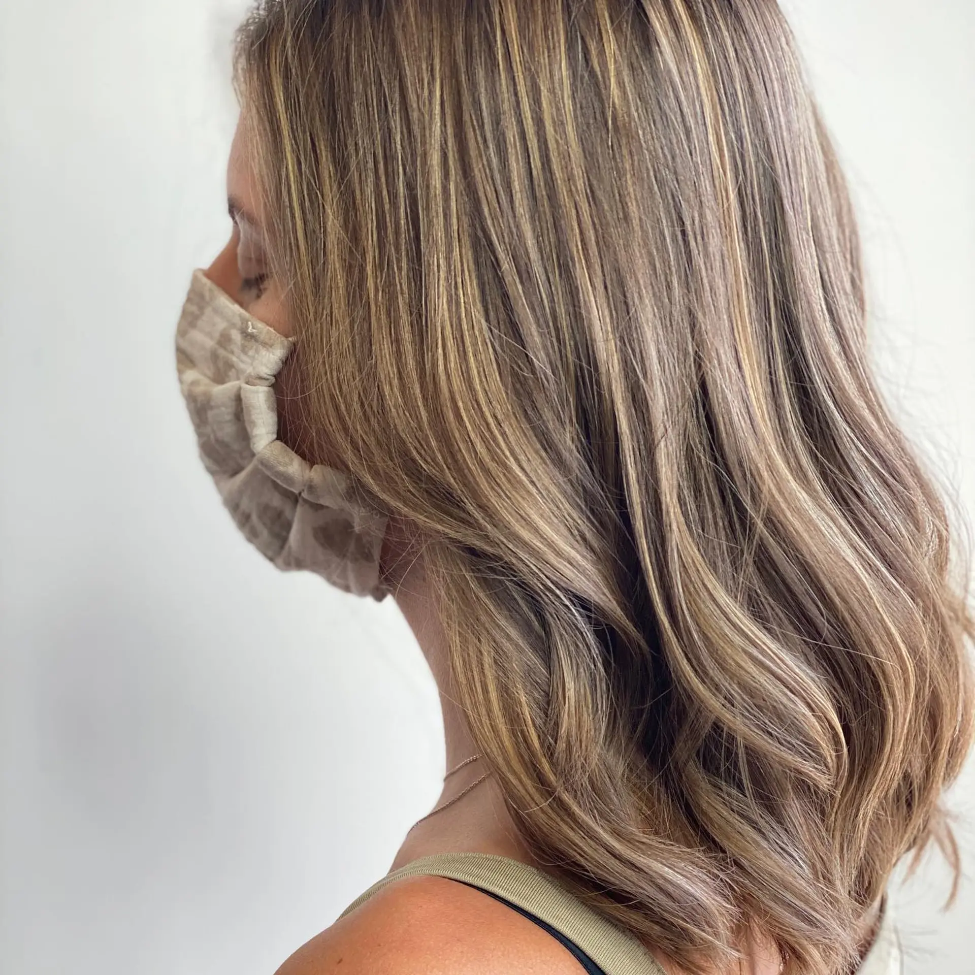 Medium-length dimensional hair featuring finely blended blonde highlights over a light brown base, styled with loose, relaxed waves. 1