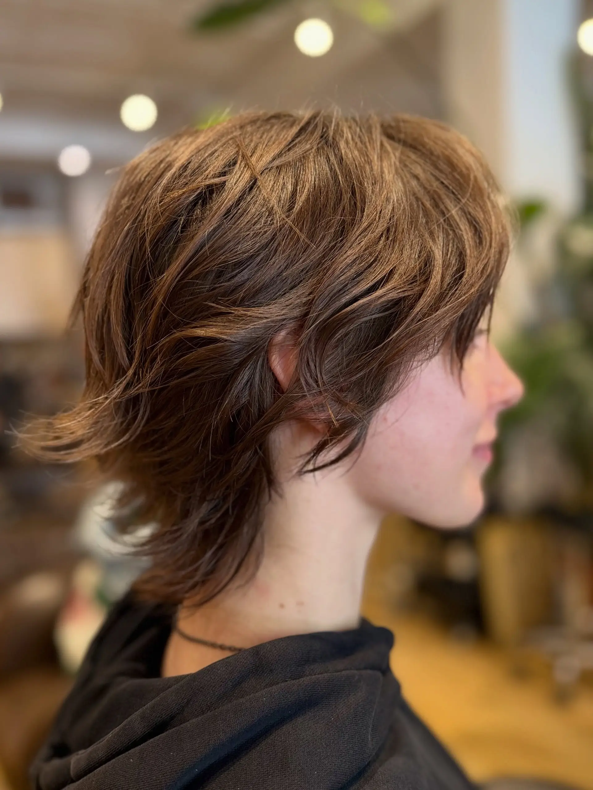 A short, layered bixie haircut styled with tousled texture and soft, outward-flicking ends at the nape. 1