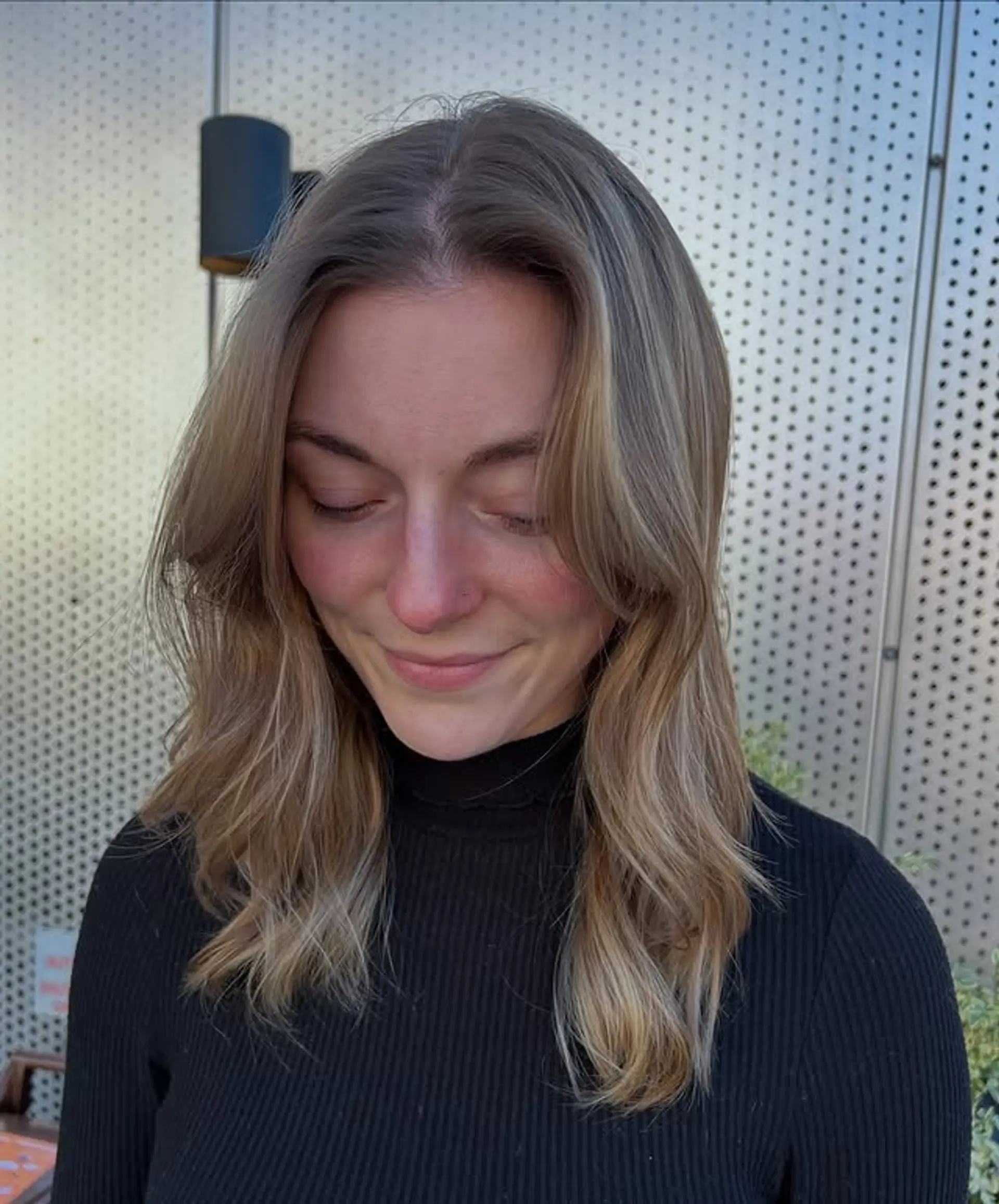 A trendy wavy hairstyle with face-framing curtain bangs and soft layers. 1