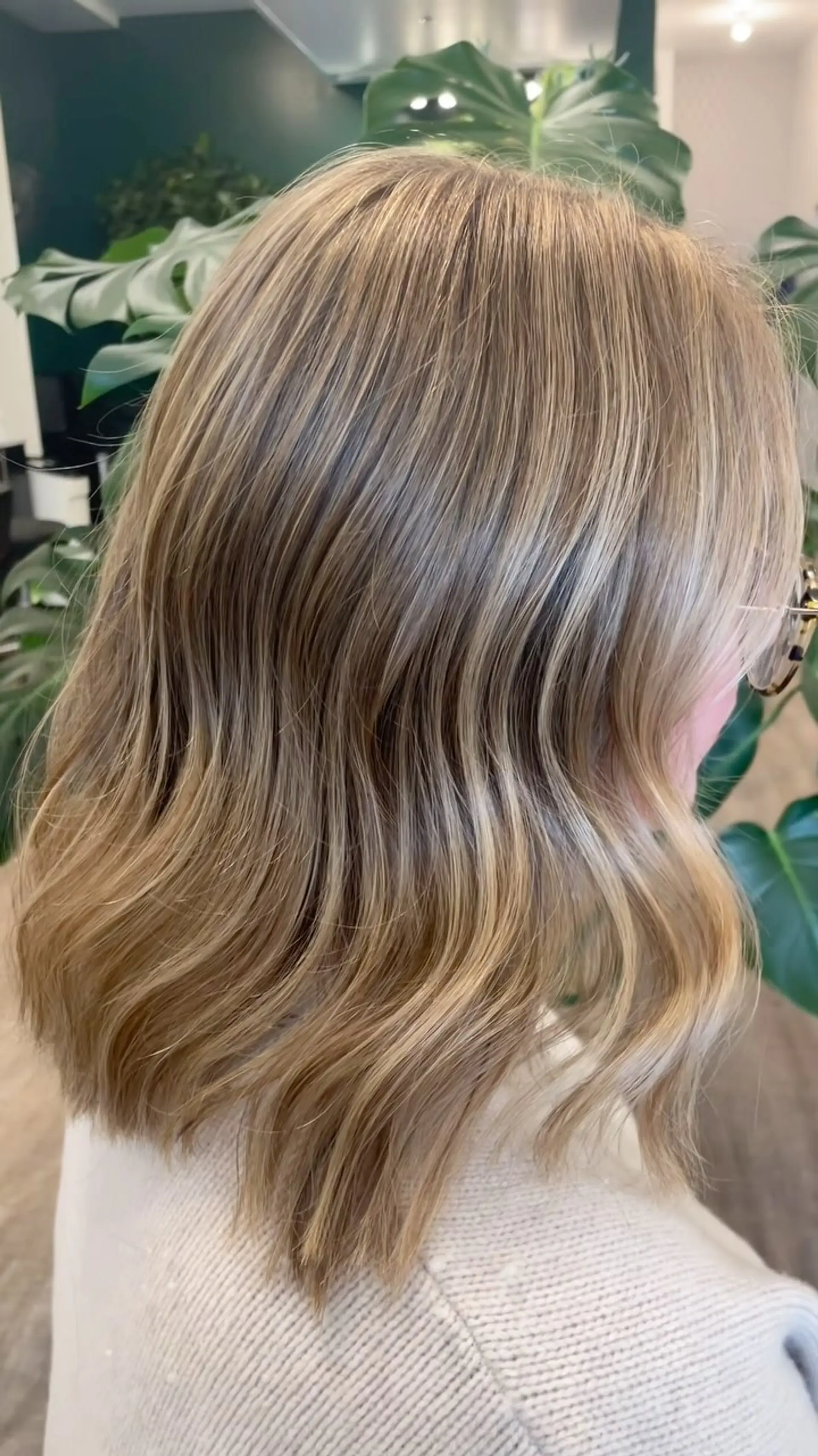 Shoulder-length lob featuring dimensional blonde highlights and soft textured waves. 1