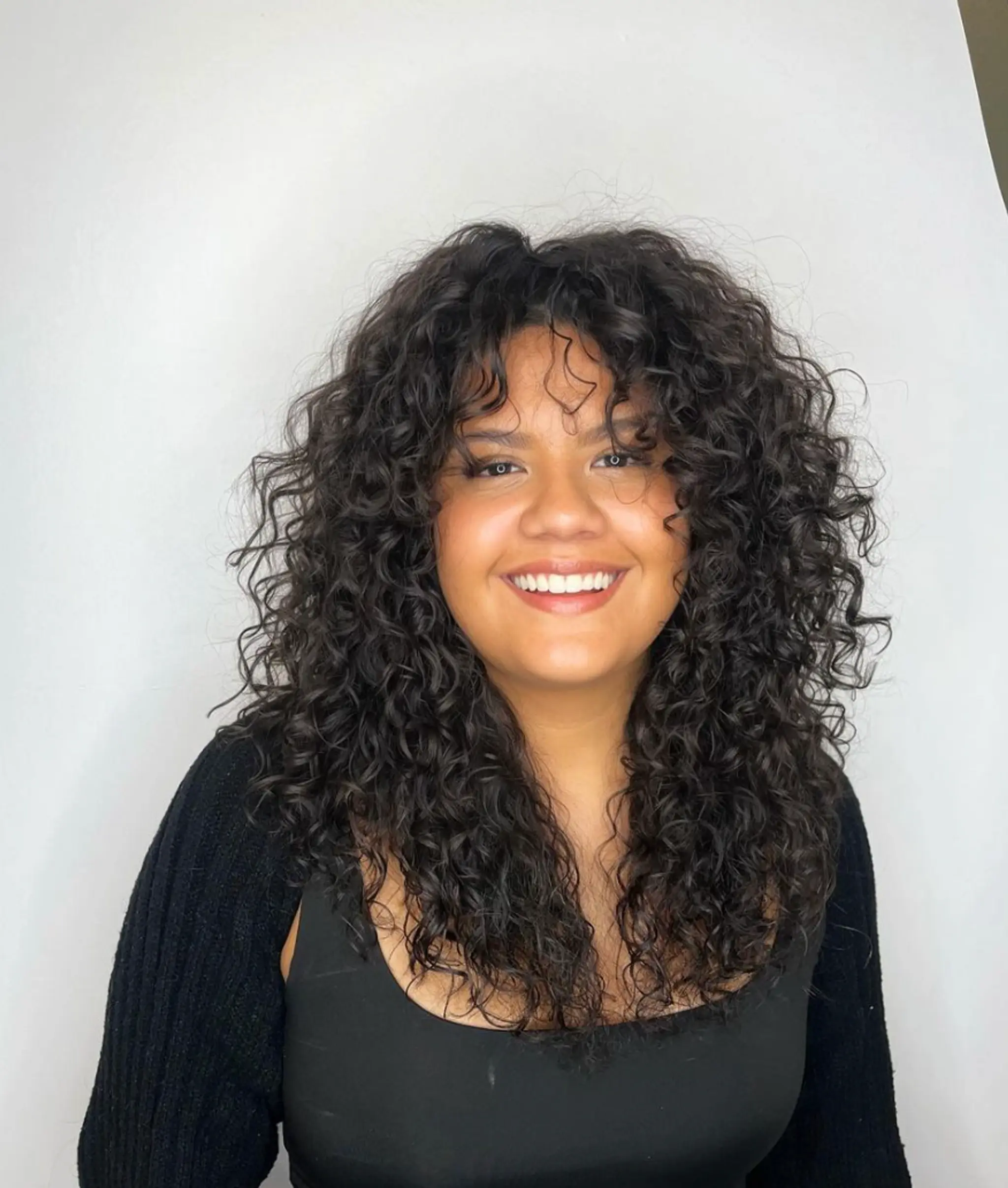 Medium-length hairstyle with voluminous, natural curls and layered, dark brown ringlets.

Cut and style by @juliamannino_hair

