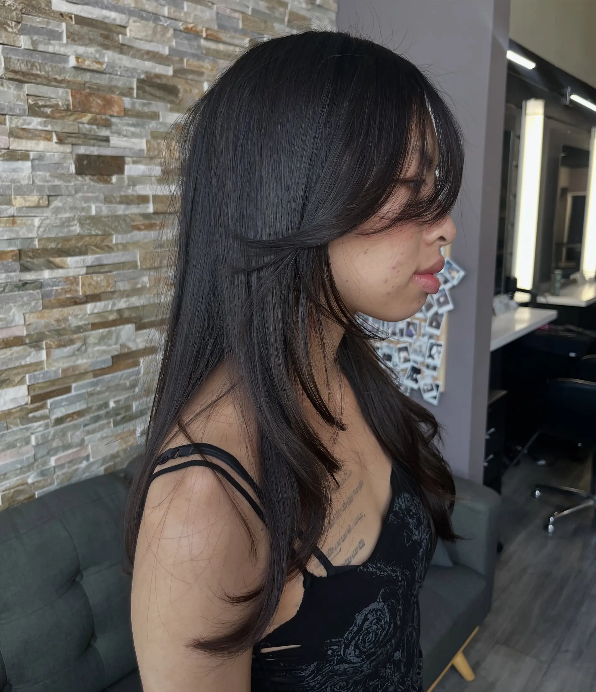 A long layered cut styled straight with soft face-framing pieces and textured side-swept bangs. 1