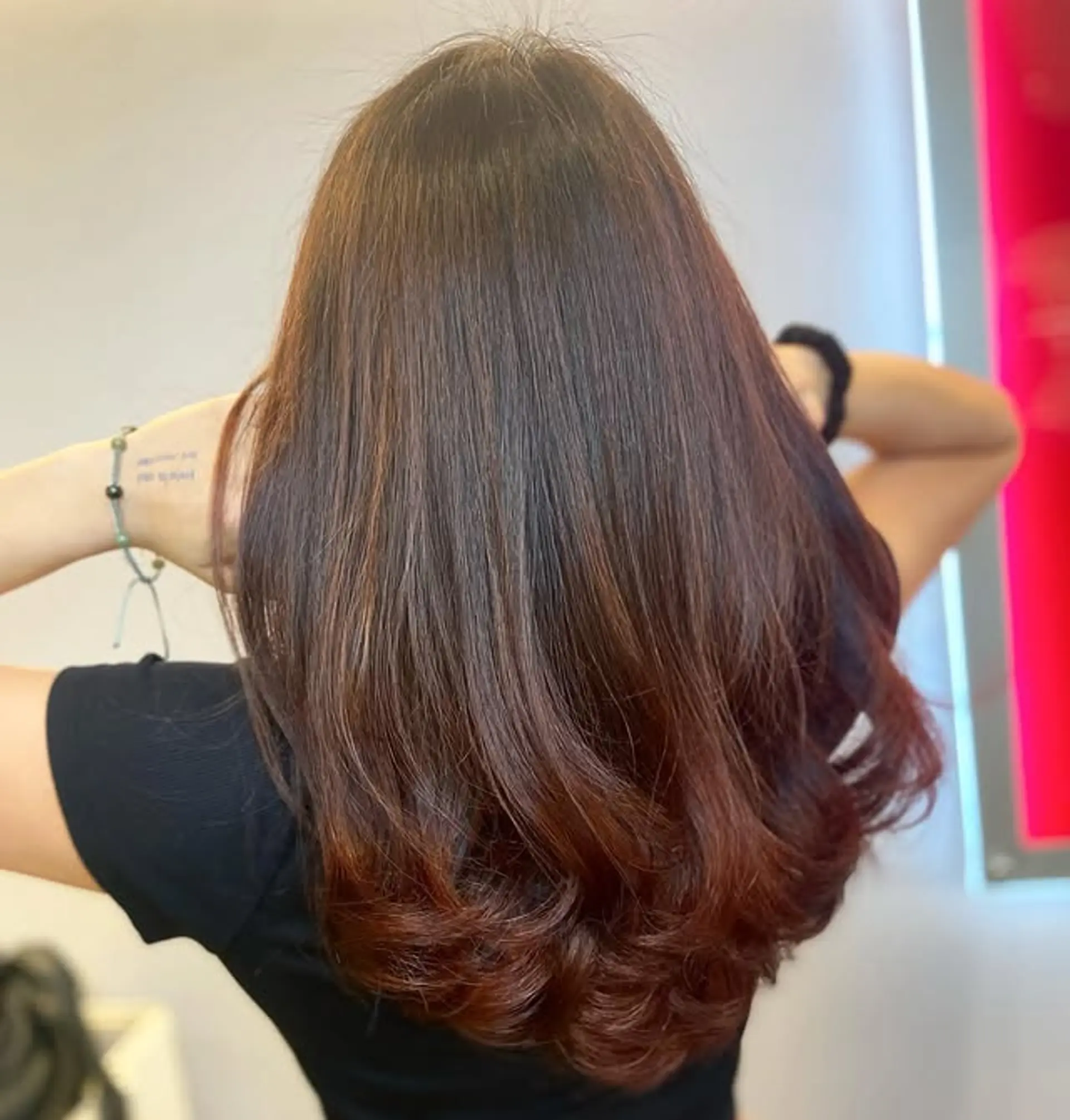A sleek, long hairstyle featuring a seamless balayage with warm auburn highlights on a chocolate brown base. 1