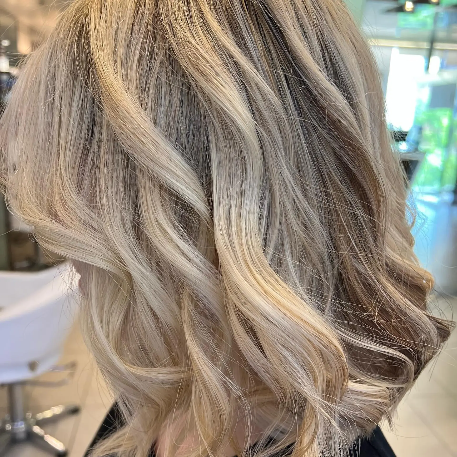 Medium-length wavy lob featuring dimensional bright blonde highlights with soft beige undertones. 1