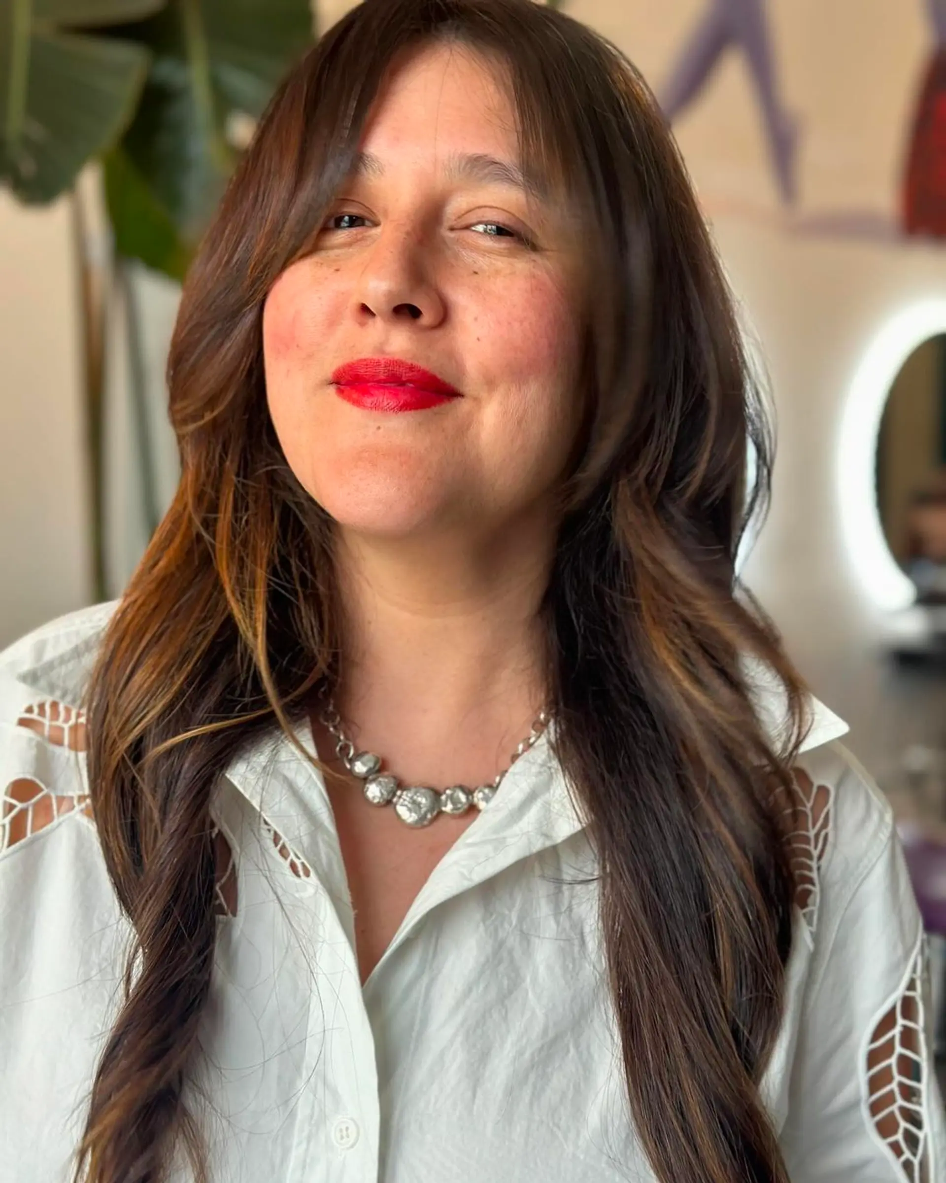 Long, straight hairstyle with soft layers and a side-swept fringe, featuring dark brown color and subtle highlights. 1