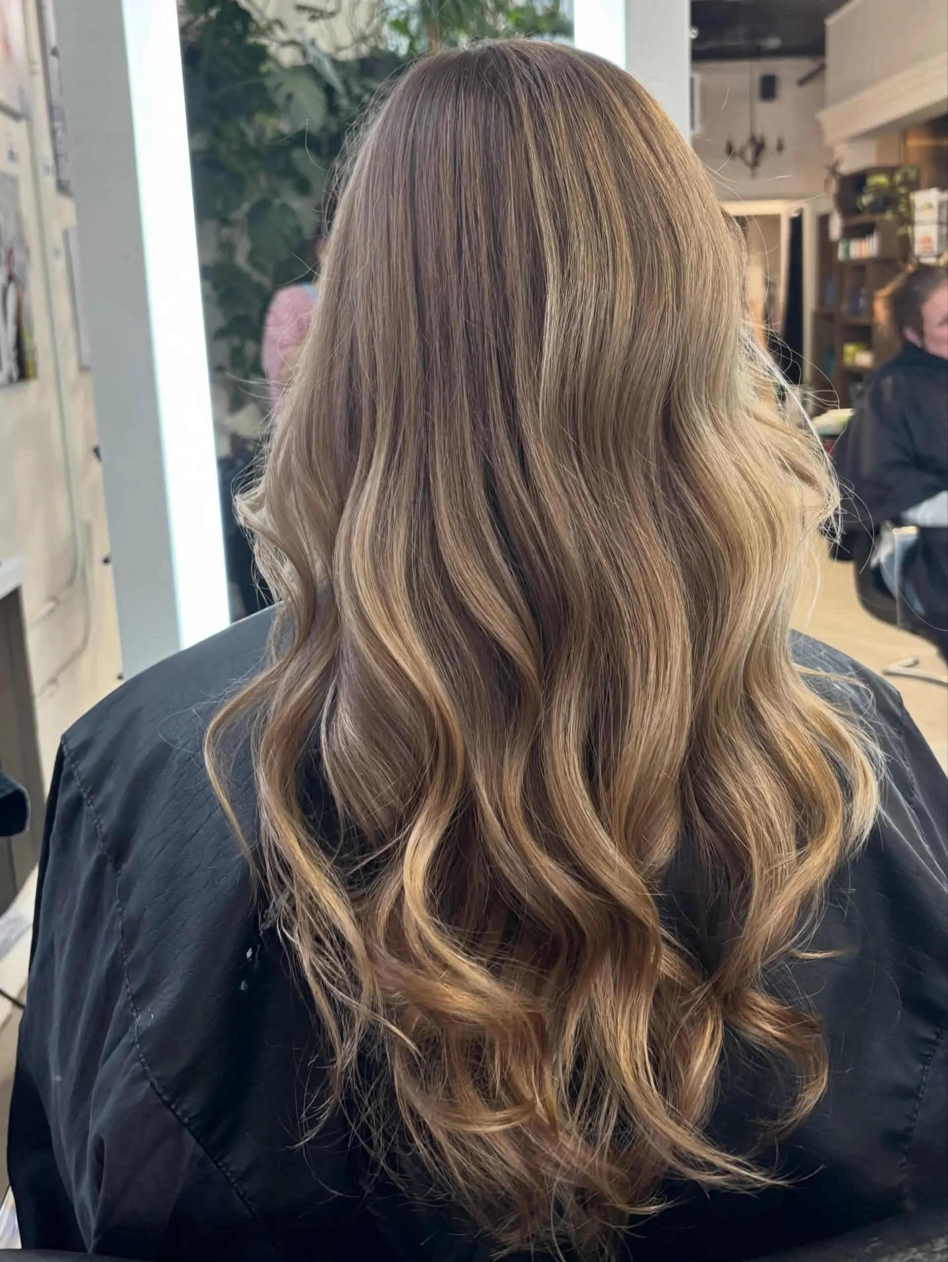 Long dimensional blonde hair styled with soft, flowing waves cascading down the back. 1