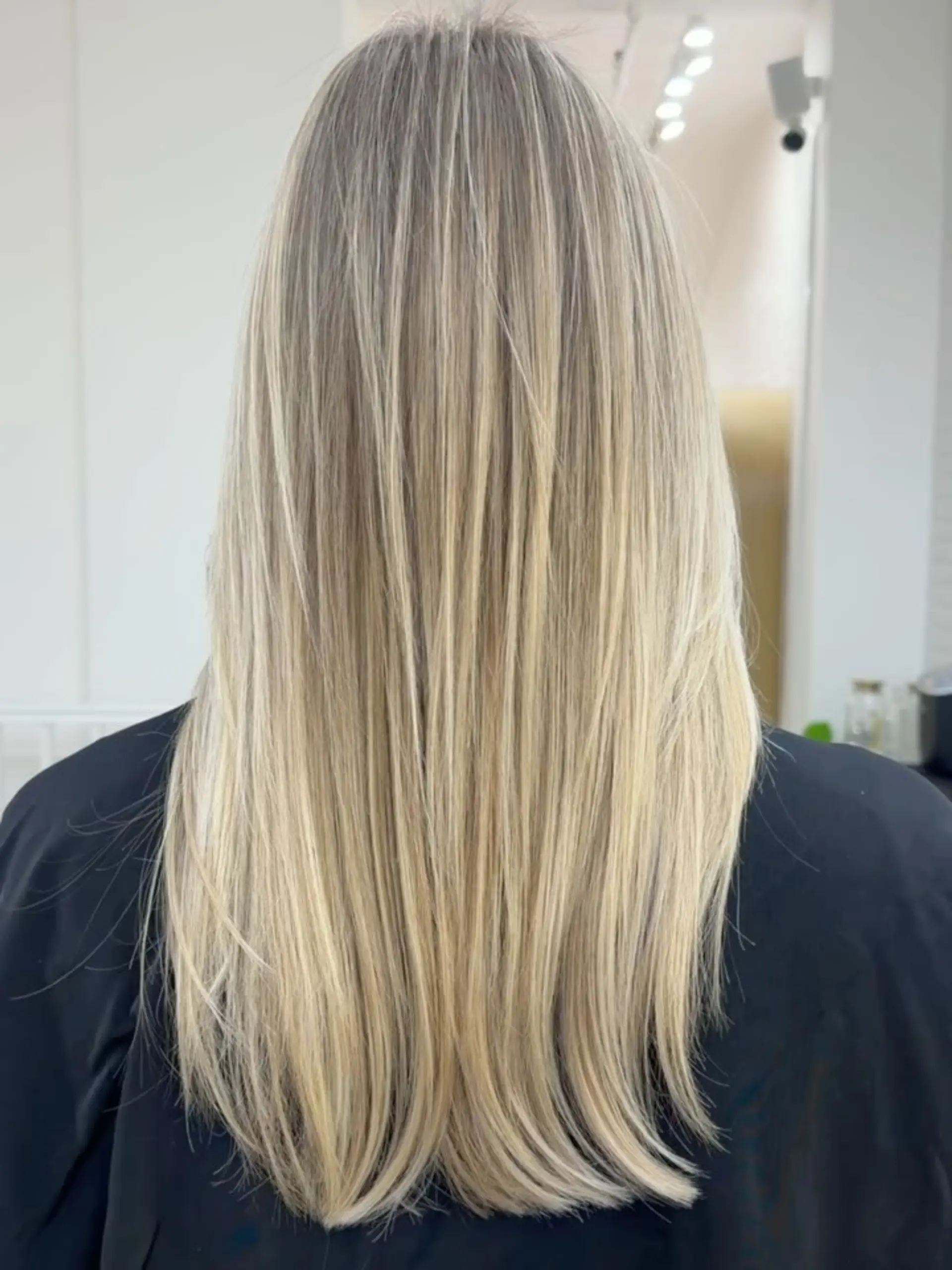 Long, straight blonde hair with fine dimensional highlights and softly tapered ends. 1