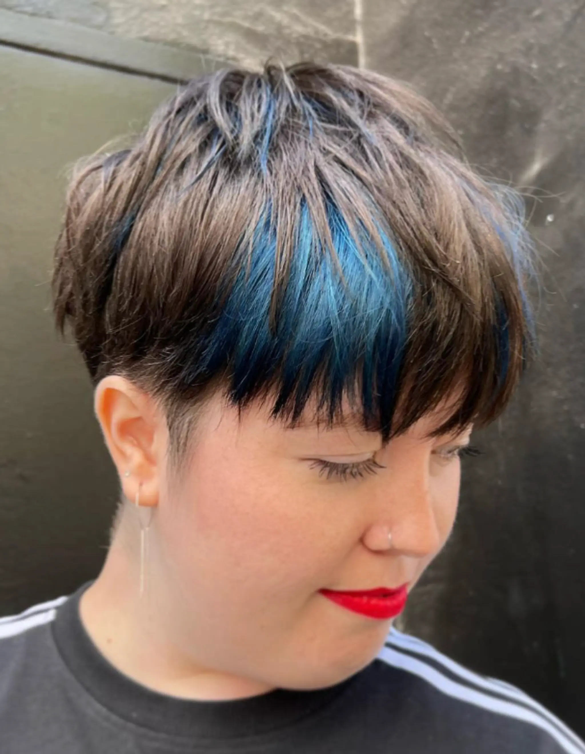 This chic and modern hairstyle features a short, straight pixie cut with vivid blue streaks. The hair is layered and includes an undercut, with a fringe sweeping gently across the forehead, adding bold and playful elements to the look.

Color by @simabeautynyc
Cut and style by @juliamannino_hair
 2