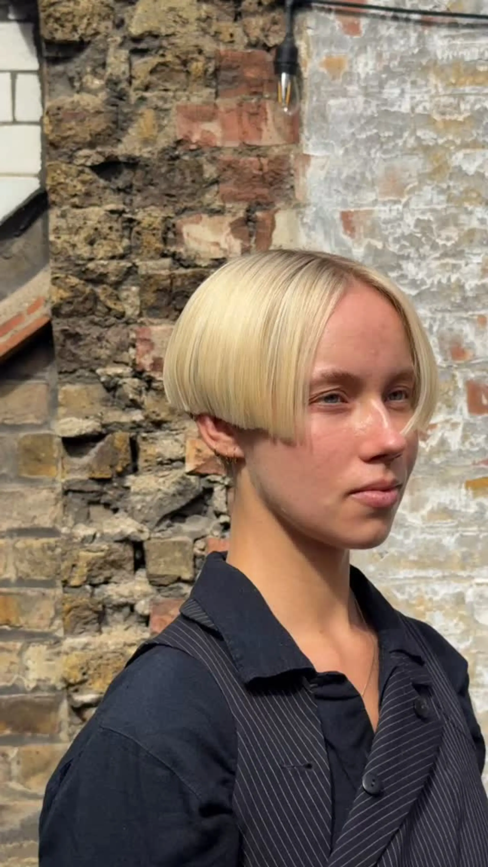 A structured, precision-cut blonde box bob parted cleanly down the center, falling at ear level. 1
