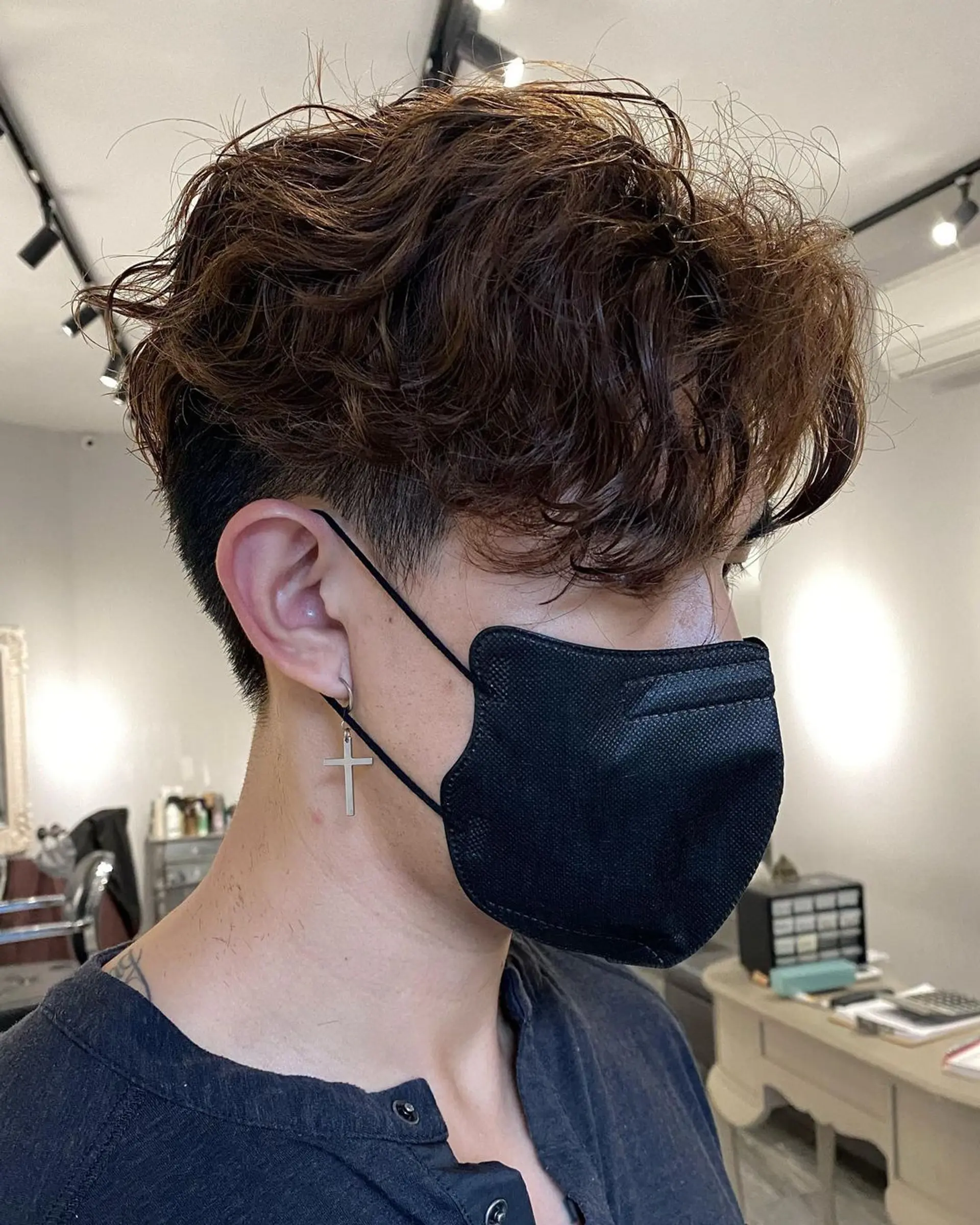 Medium-length wavy honey brown hair with voluminous, tousled waves on top, giving a natural lift and messy, layered appearance. The sides and back are slightly shorter to accentuate the textured flow on top. 2