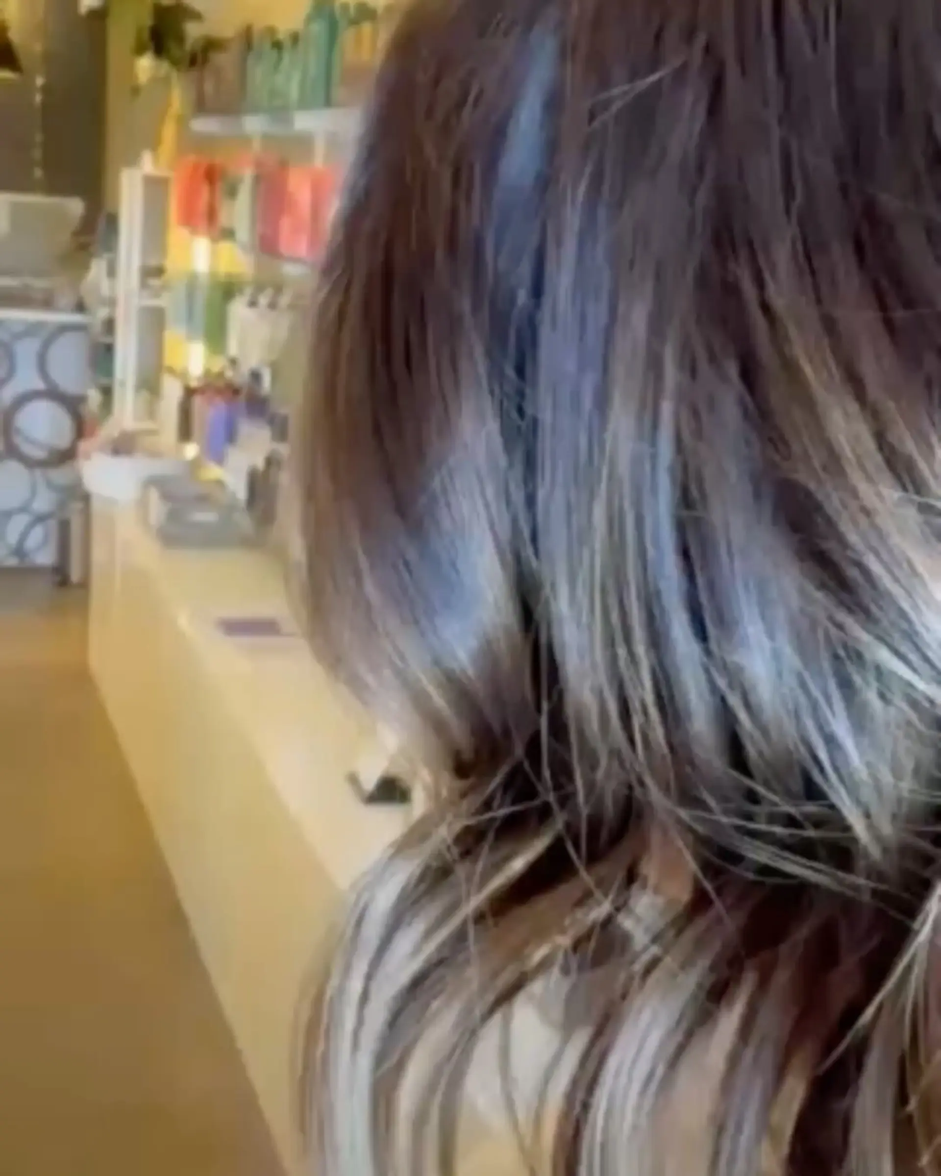 Rich dimensional brunette hair featuring finely woven warm ribbon highlights throughout soft, textured waves. 1