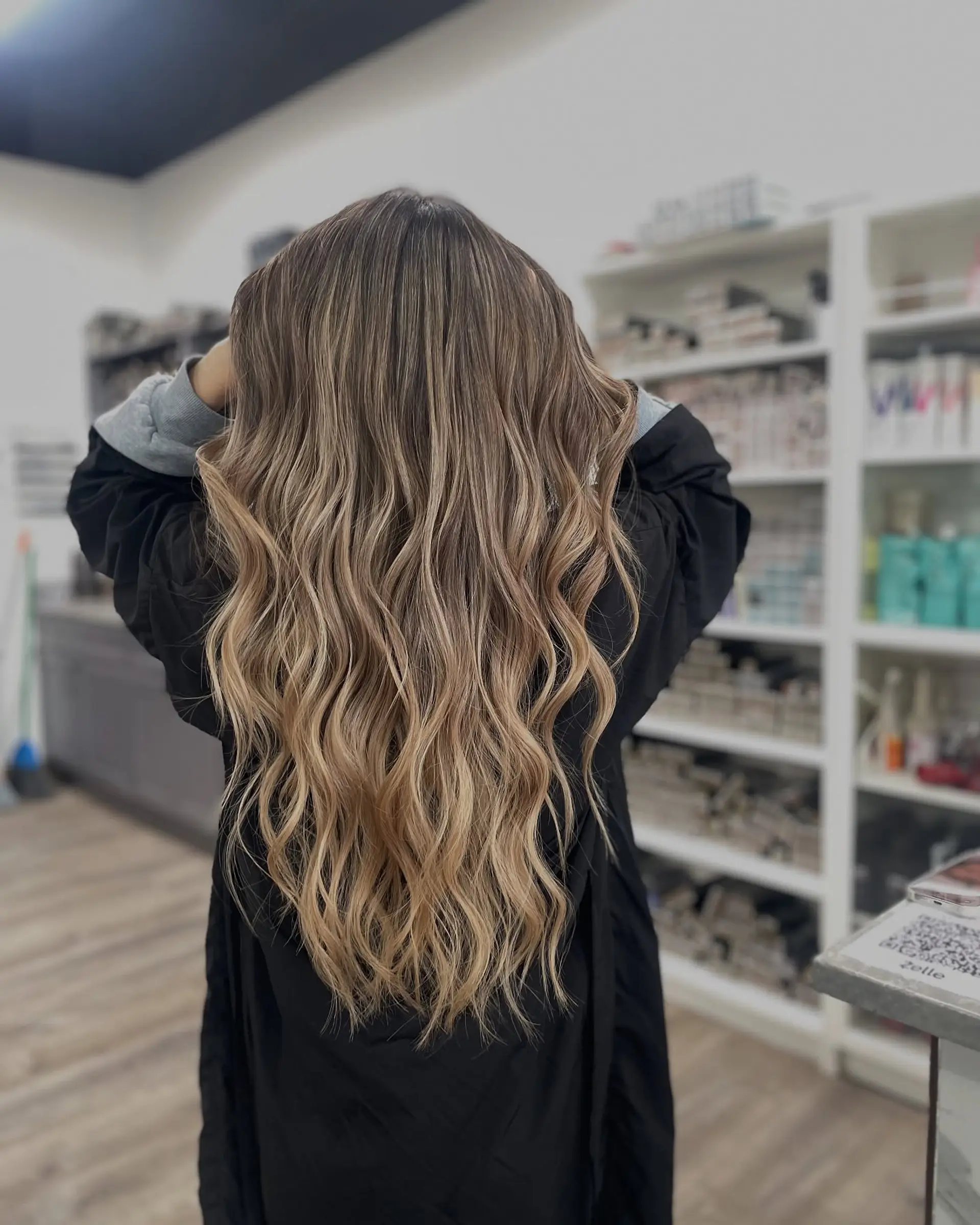 Long, layered wavy hairstyle with a blonde balayage. 1