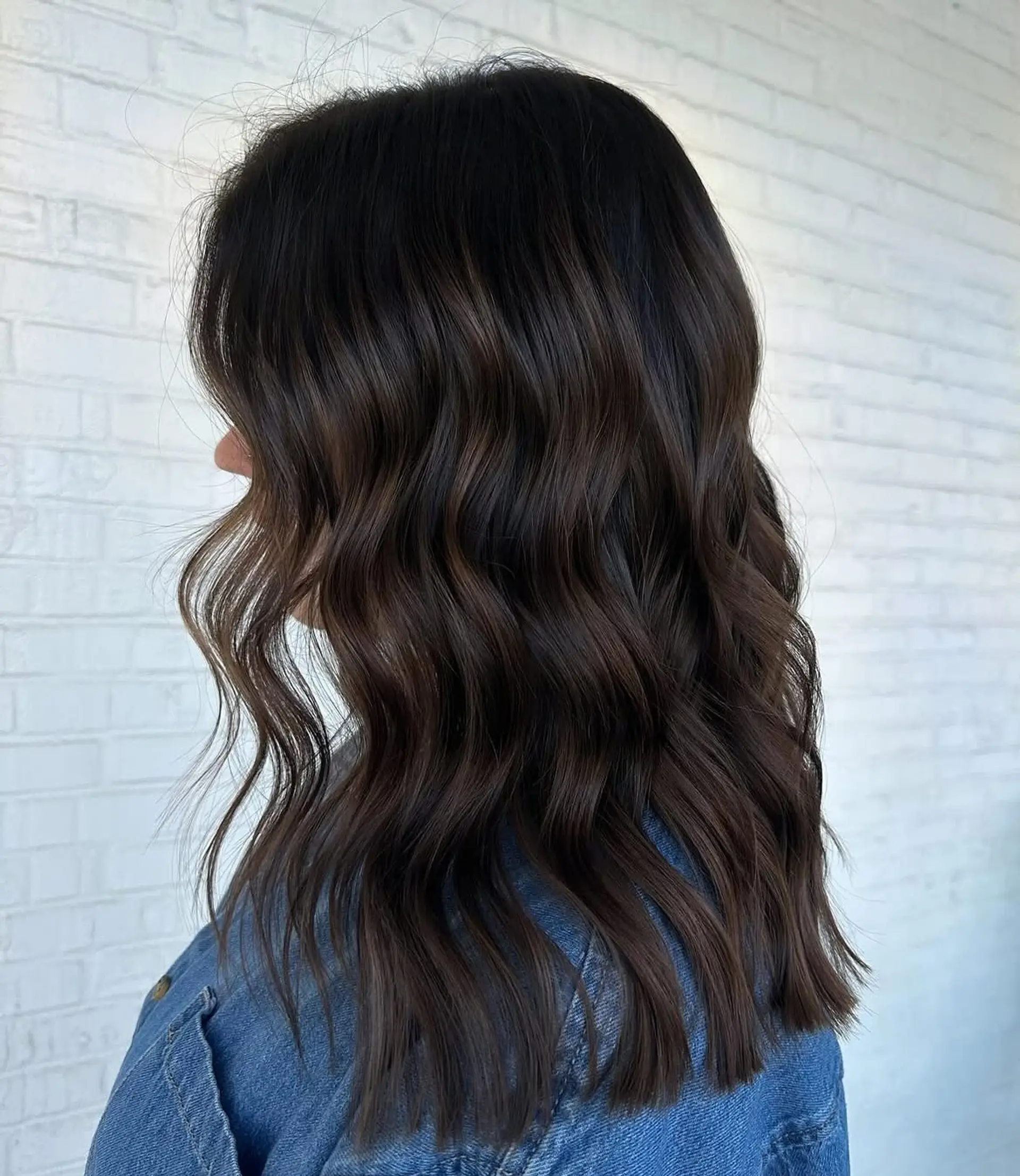 Shoulder-length rich espresso brunette hair featuring subtle chocolate dimension and styled with relaxed, textured waves. 1