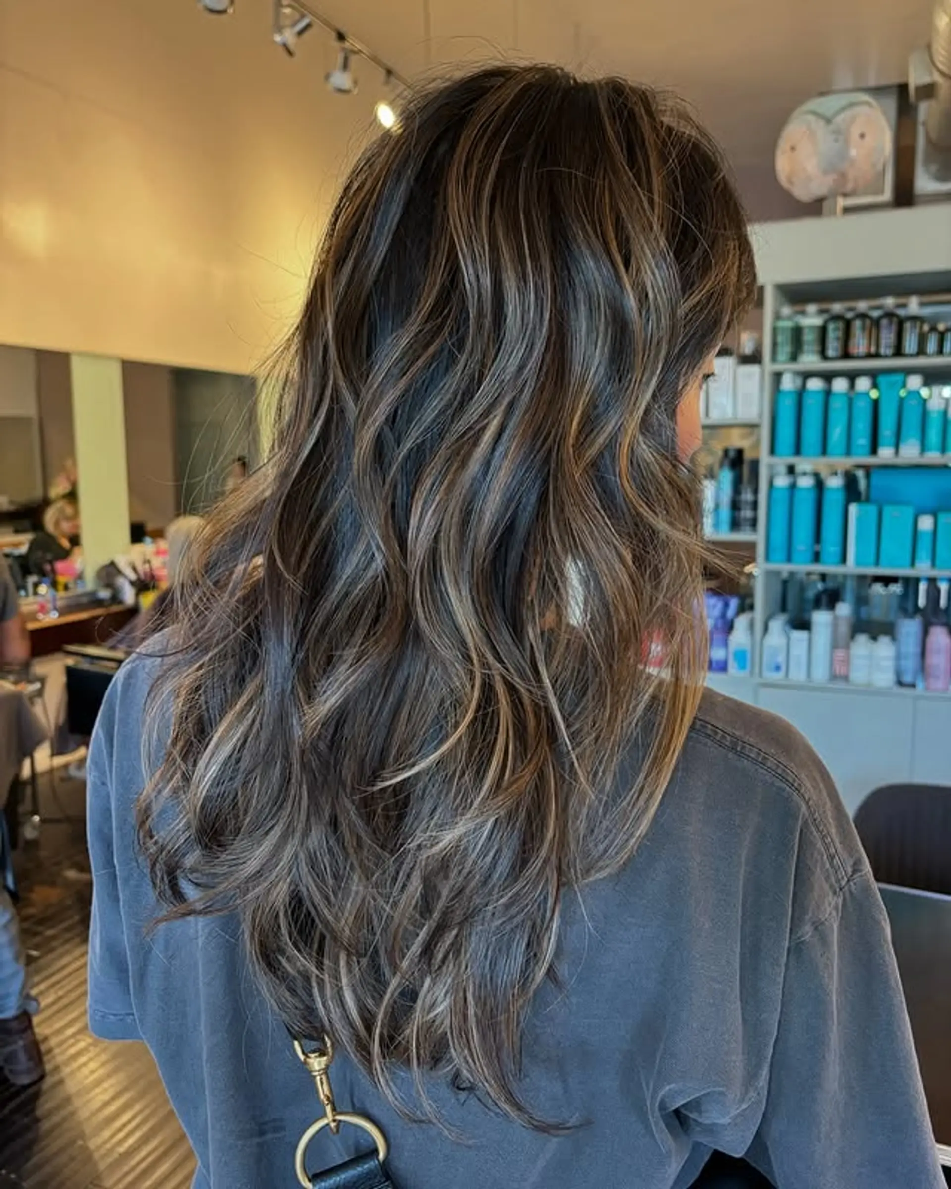A wavy medium-length hairstyle with caramel balayage highlights. 1