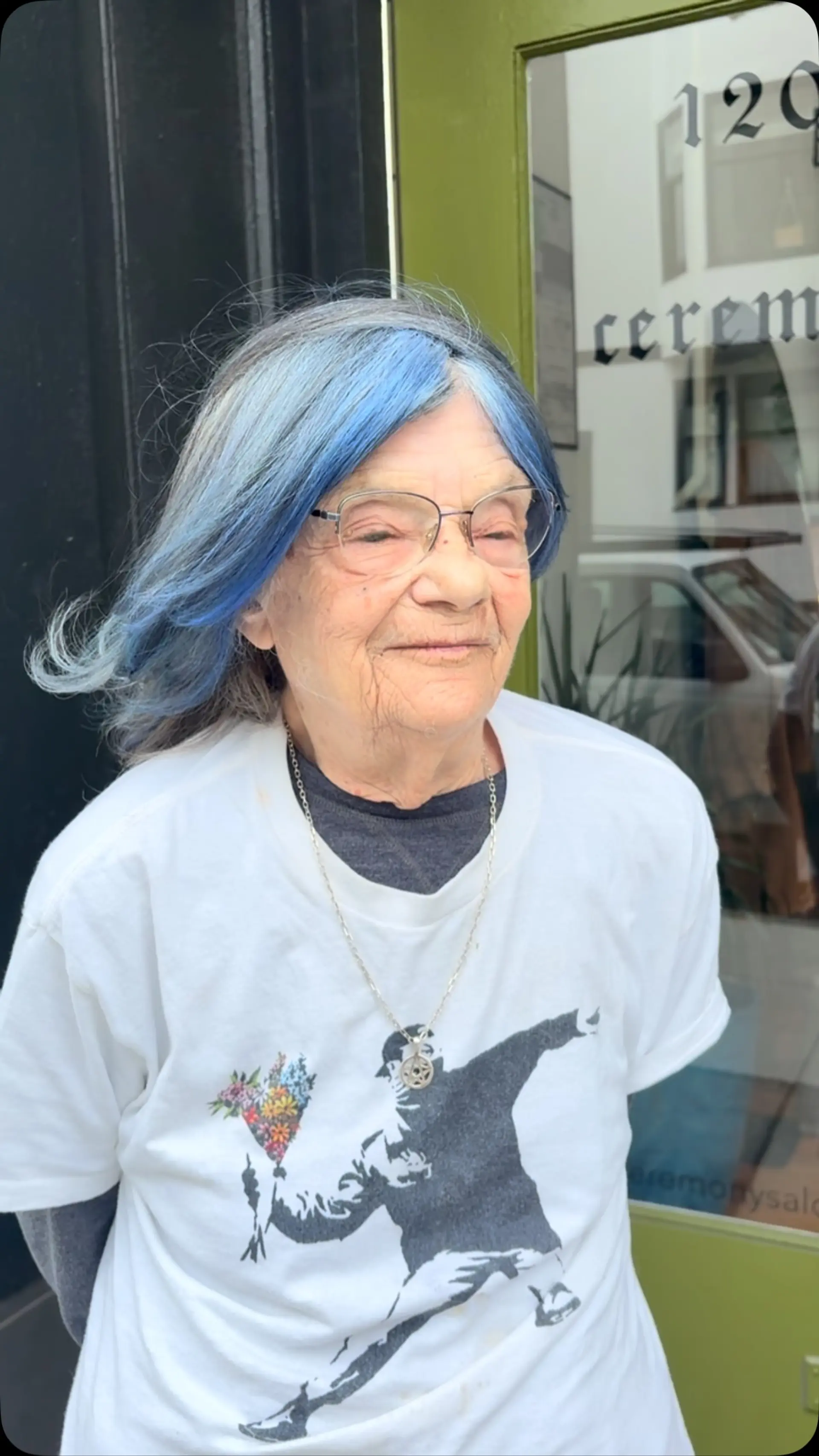 Medium-length silver-grey hair styled with flipped ends and vibrant blue color concentrated across the front fringe. 1