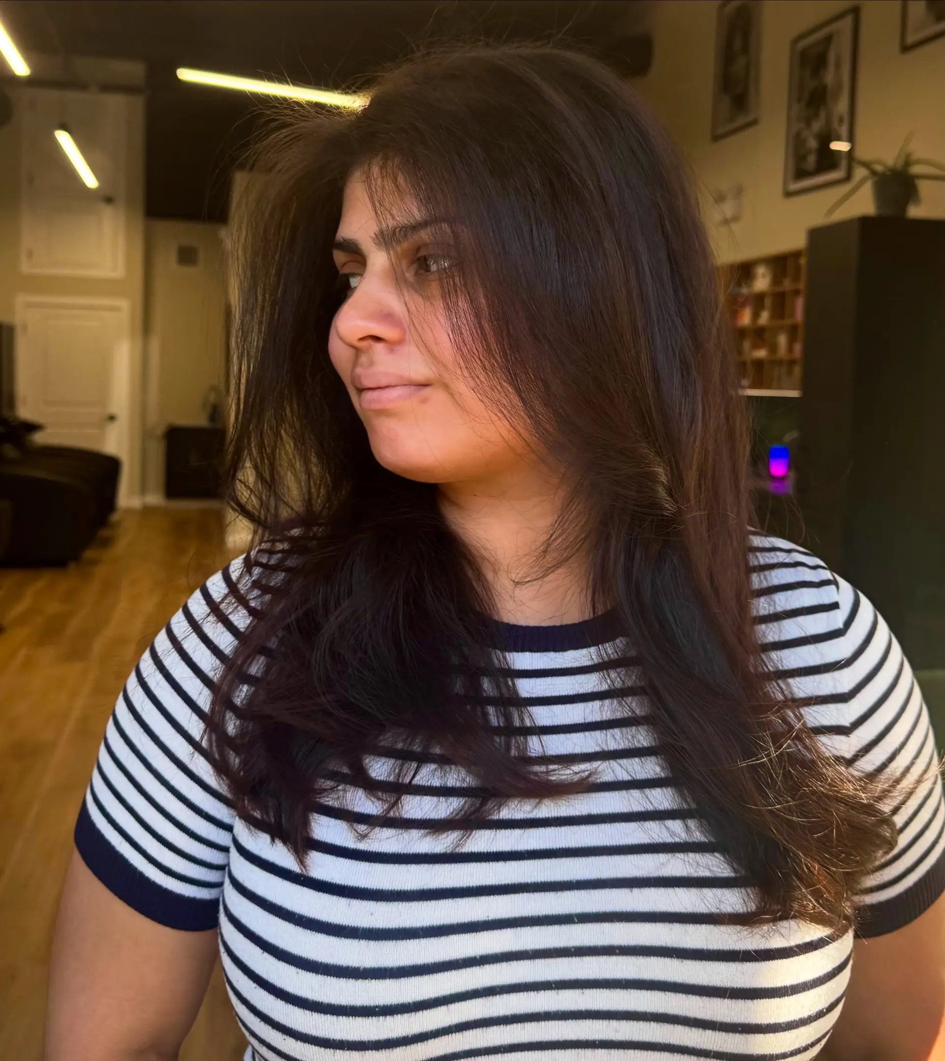 A soft, voluminous blowout on long dark brown hair featuring face-framing layers and subtle movement. 1