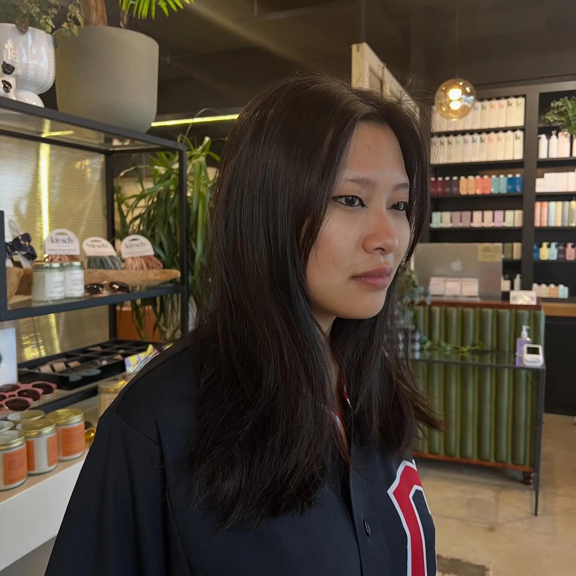 Medium-length dark hair styled straight with soft textured ends and curtain-style face-framing layers. 1